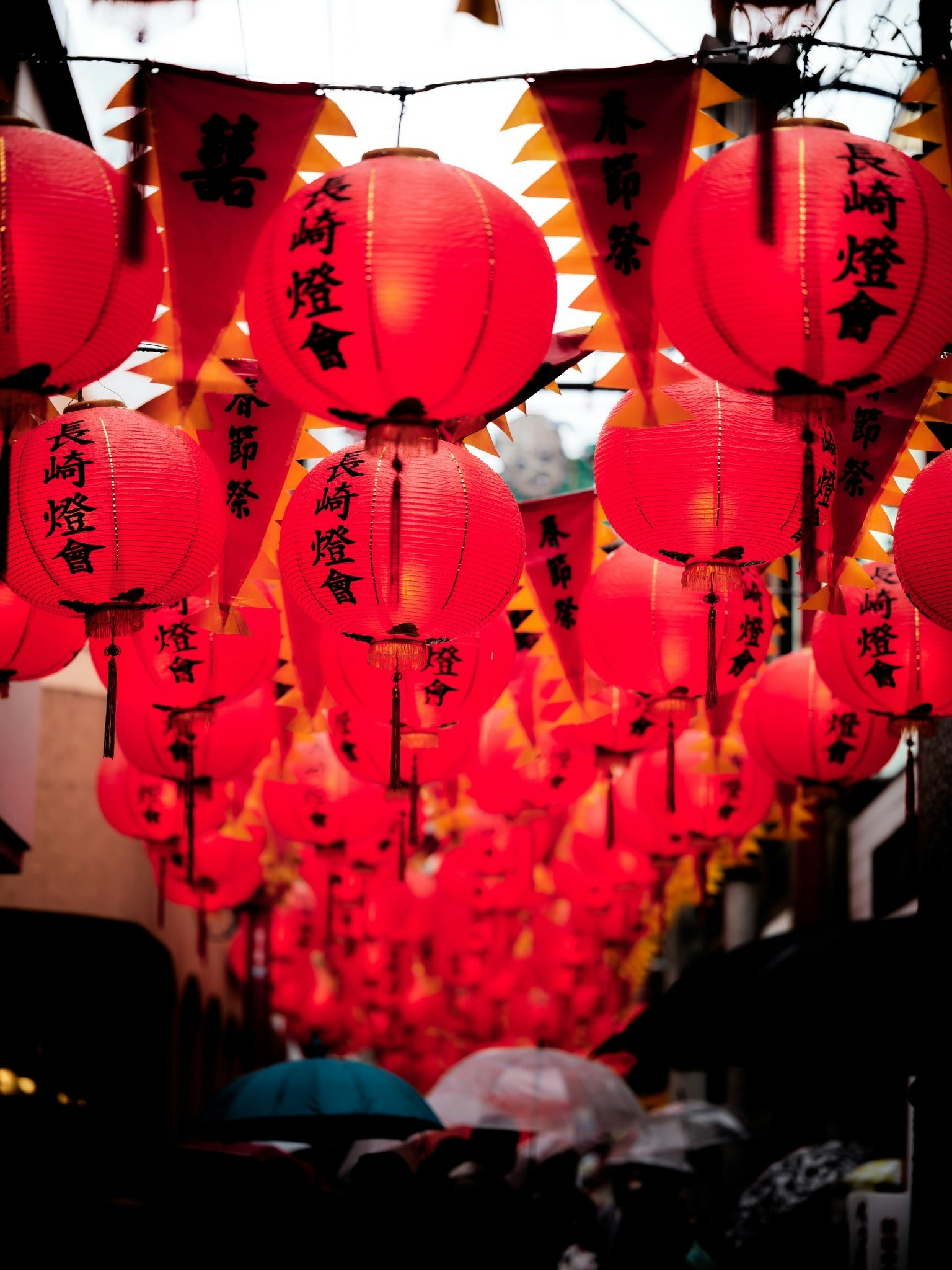 Scène de rue vibrante avec des lanternes rouges et des drapeaux suspendus