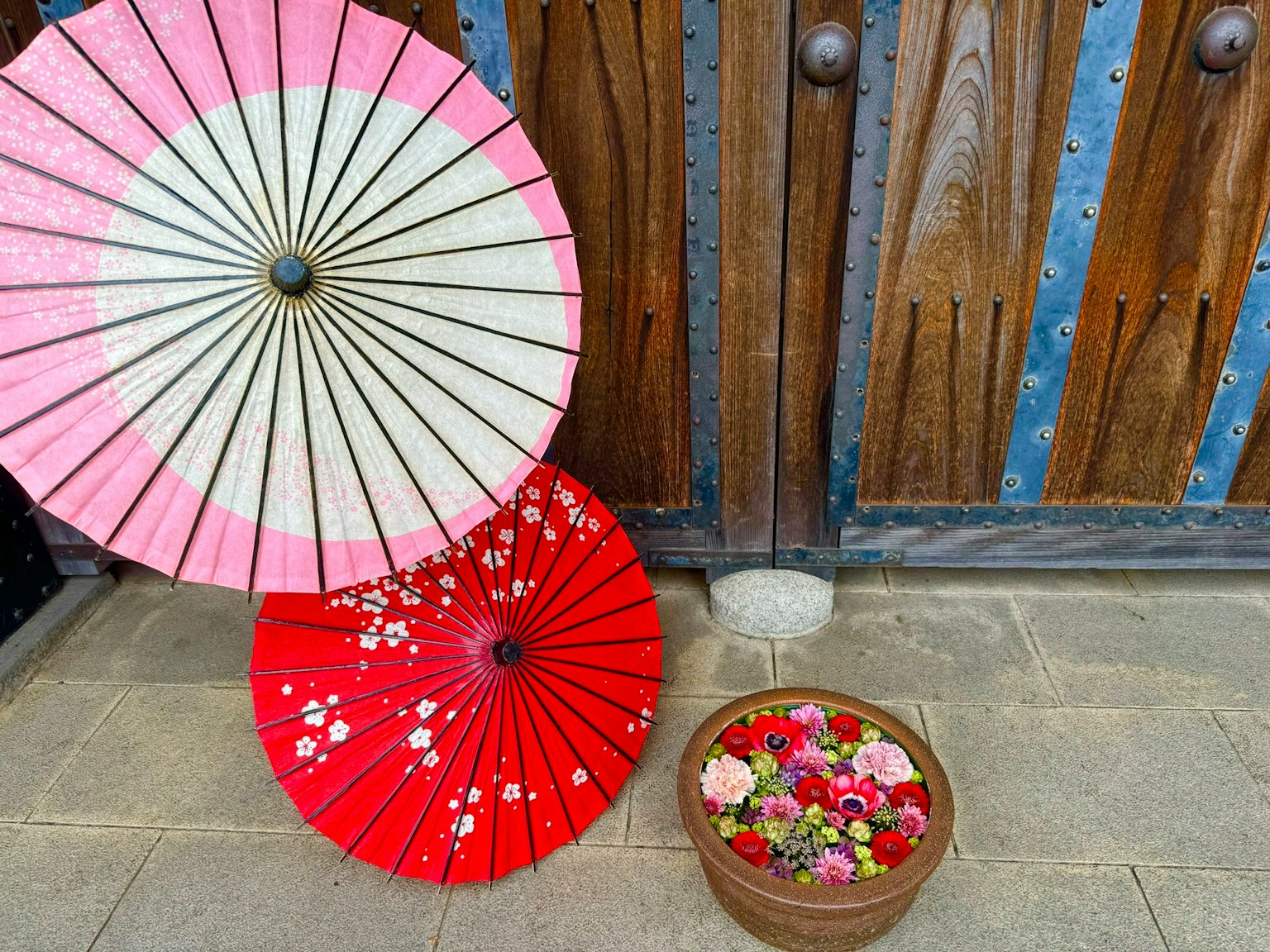Scène japonaise traditionnelle avec des parapluies rouges et roses et un panier de fleurs