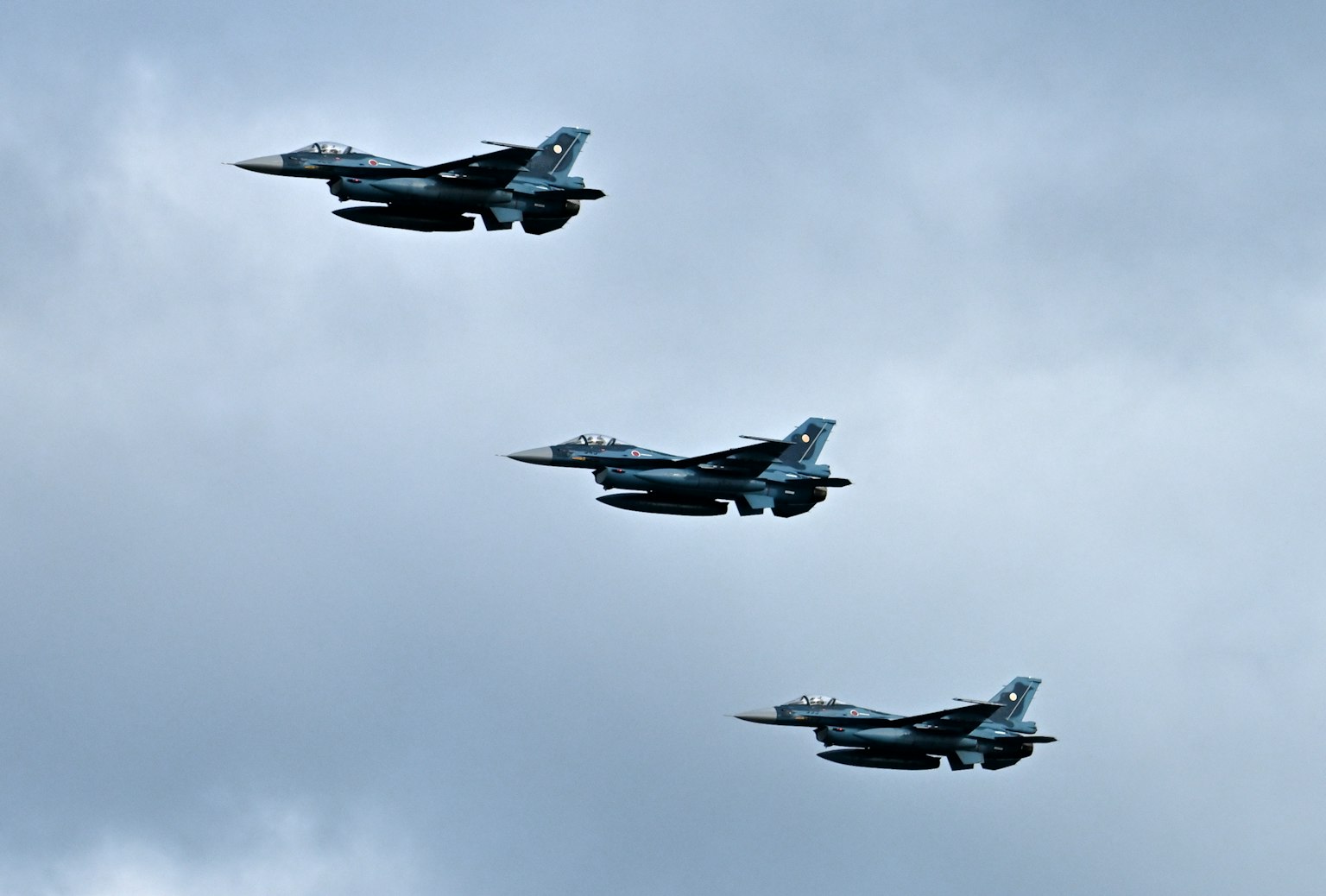 Tres aviones de combate volando en formación contra un cielo nublado