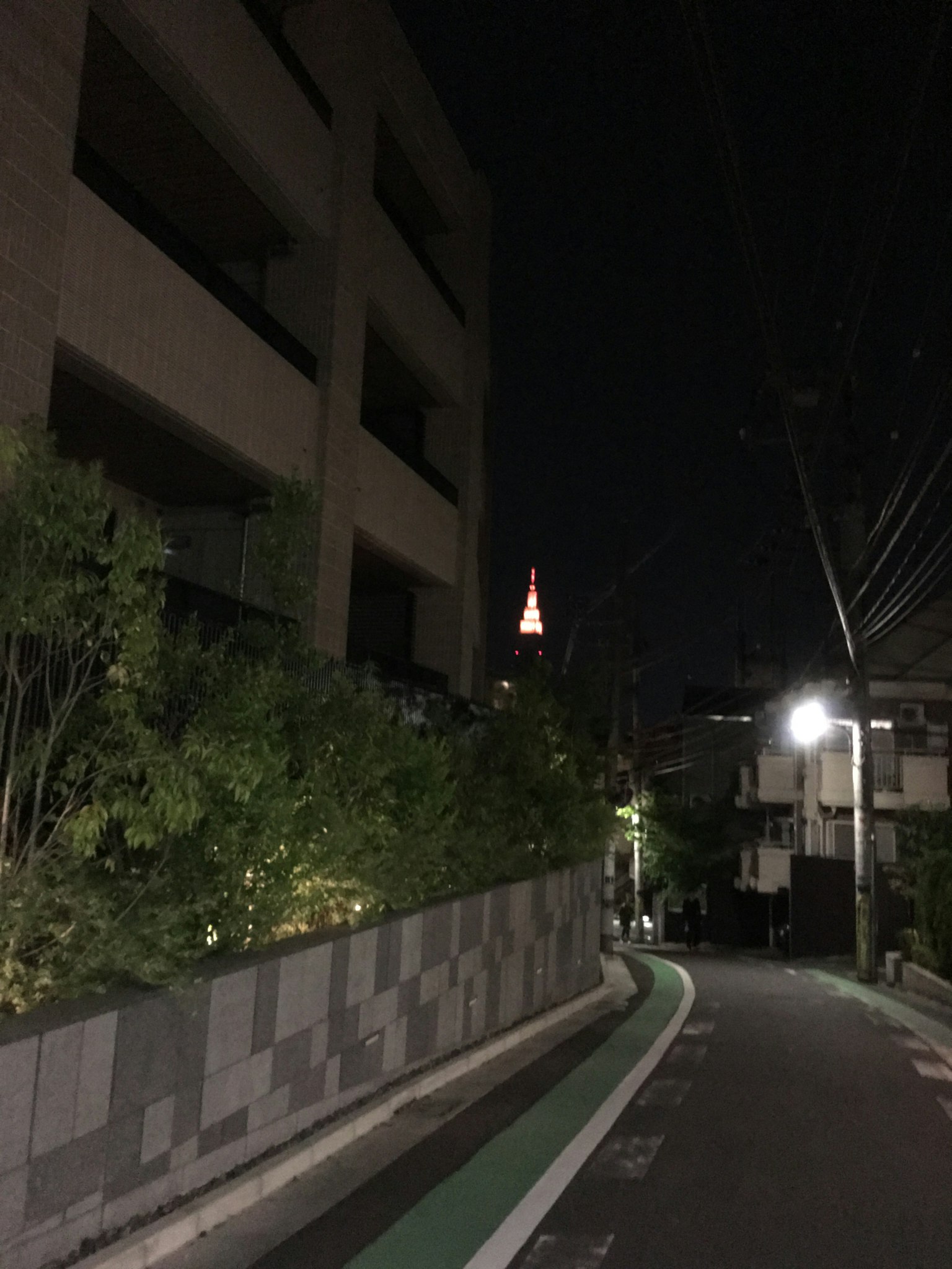 Jalan sepi di malam hari dengan tampilan Menara Tokyo di latar belakang