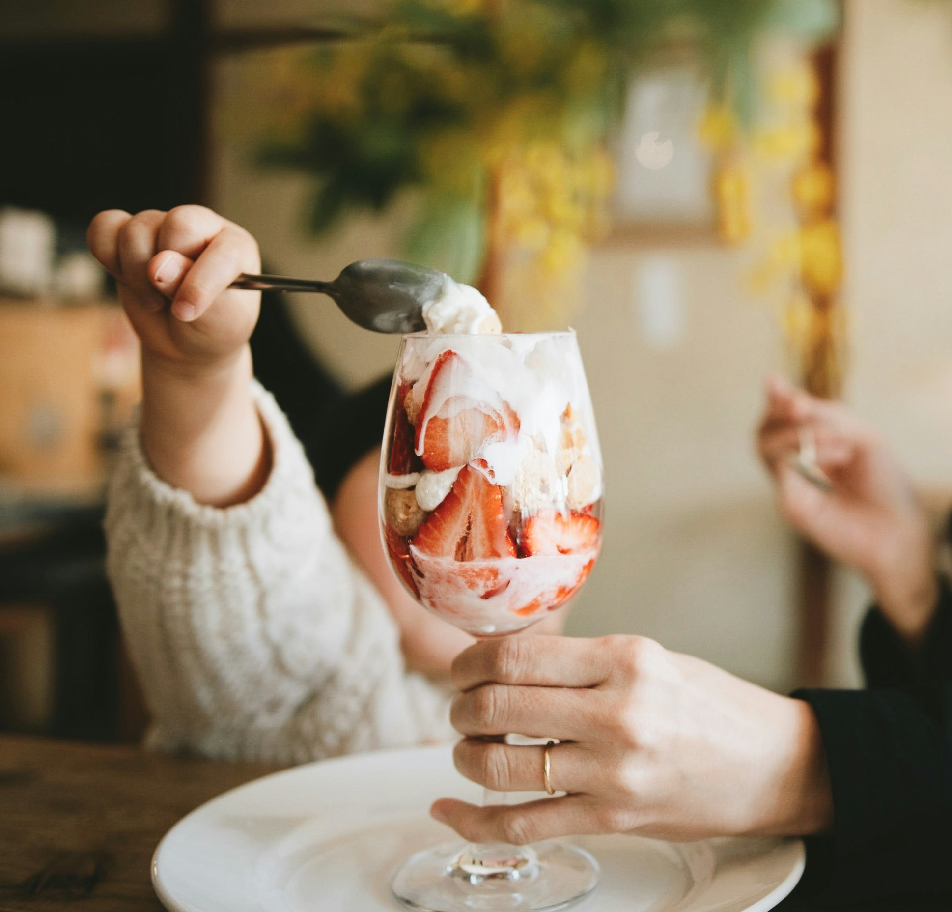 Anstoßen mit einem mit Eis gefüllten Cocktail, der in ein Glas gegossen wird