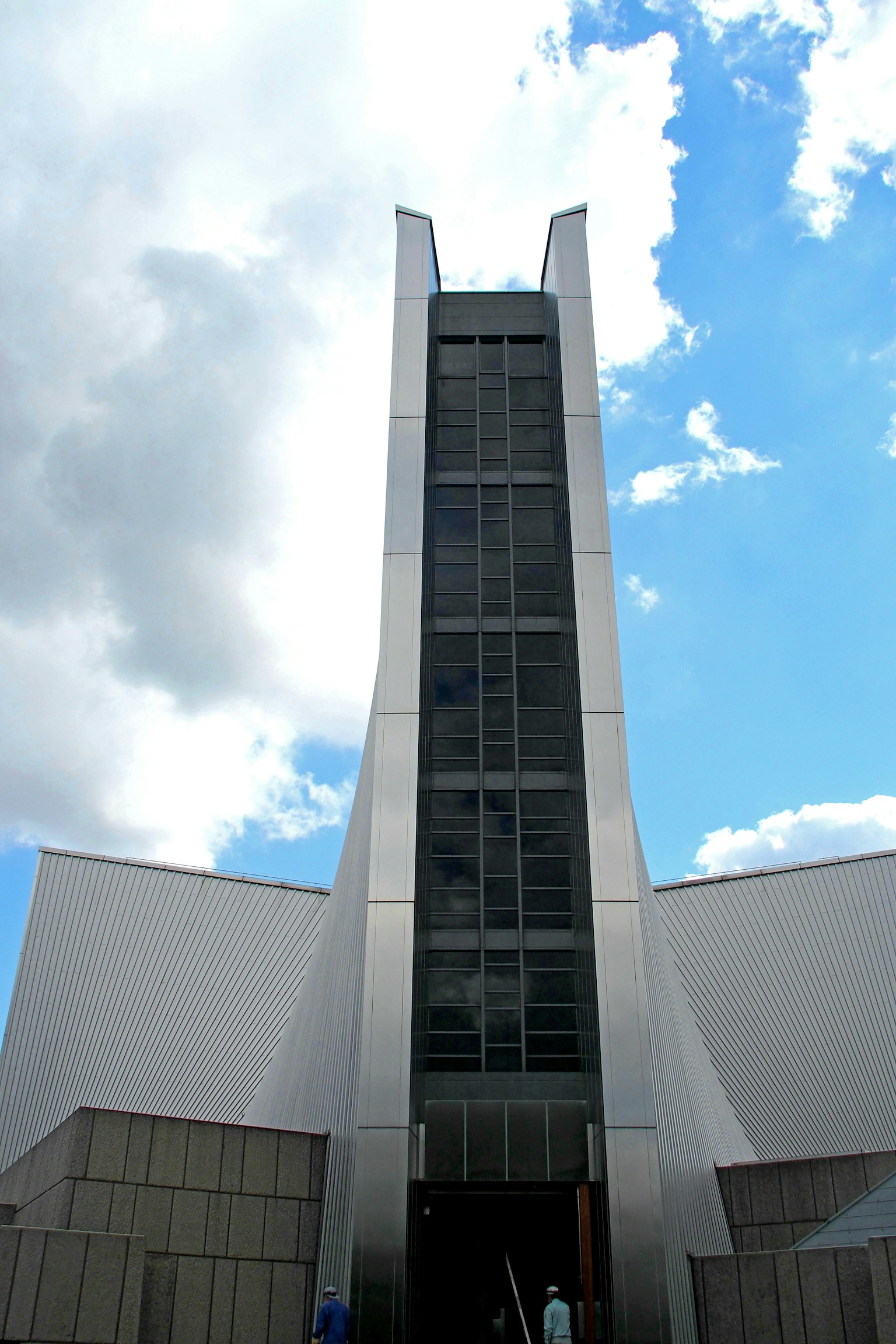 Fachada arquitectónica moderna con un diseño alto contra un cielo azul