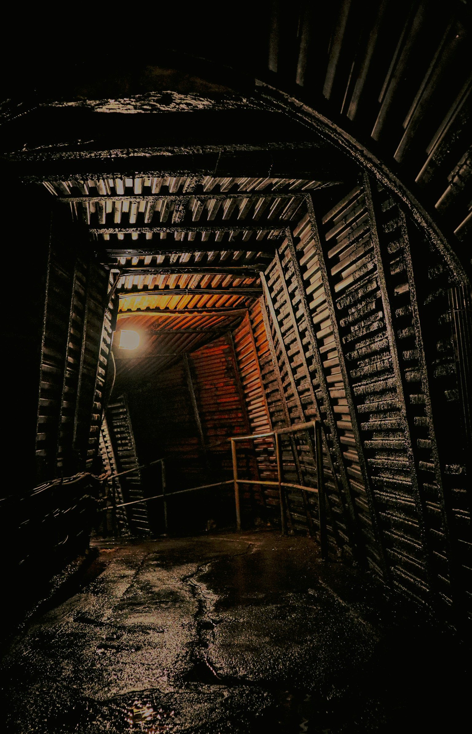Interior terowongan gelap dengan struktur kayu dan pencahayaan