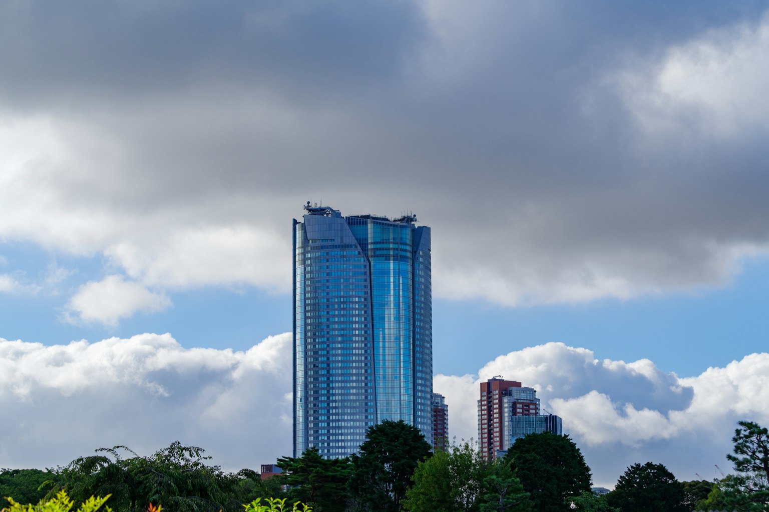 Un alto edificio si erge sotto un cielo blu con nuvole