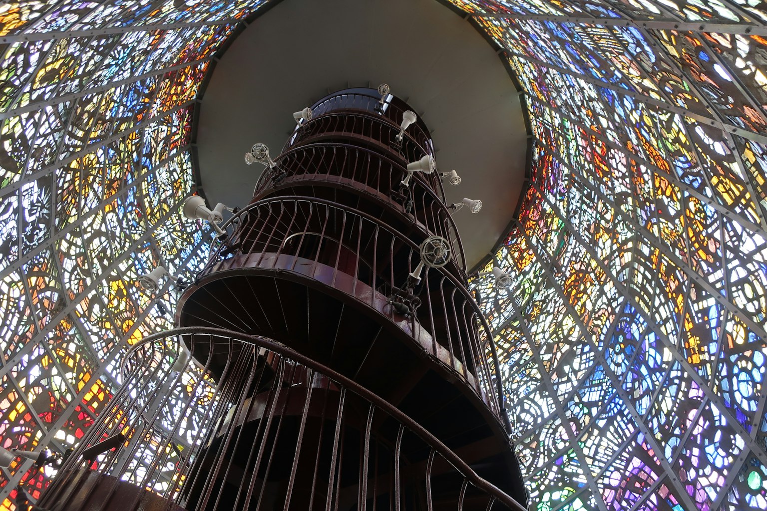 Intérieur d'un escalier en colimaçon entouré de vitraux colorés