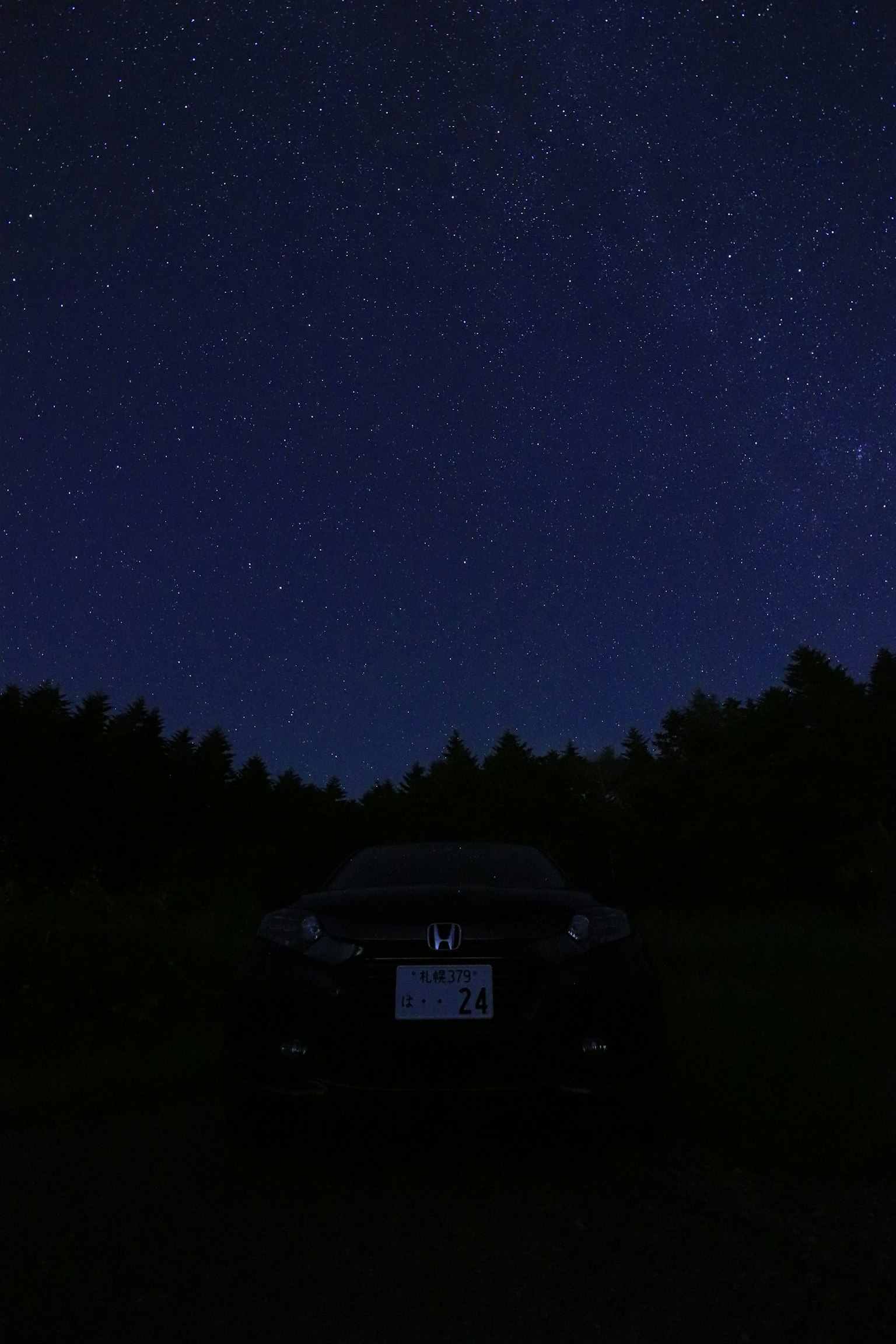 Silhouette di un'auto sotto un cielo stellato