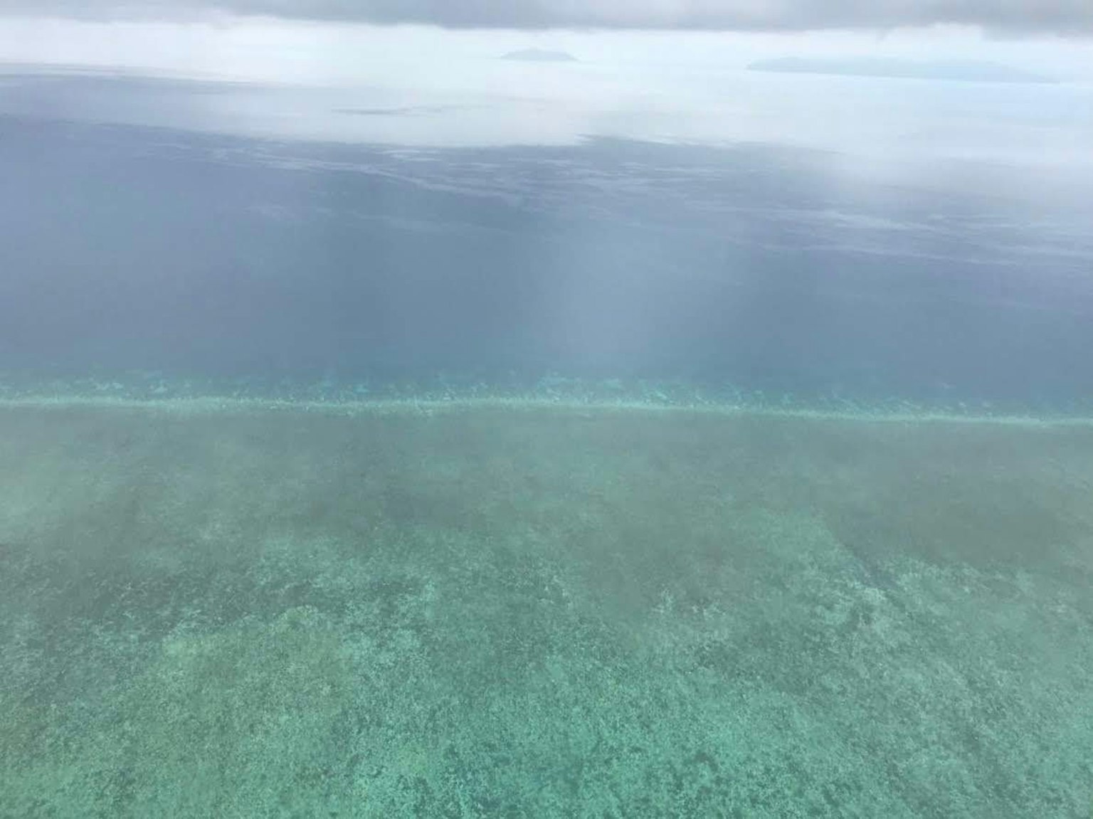 Vista aérea de agua turquesa y arrecife de coral
