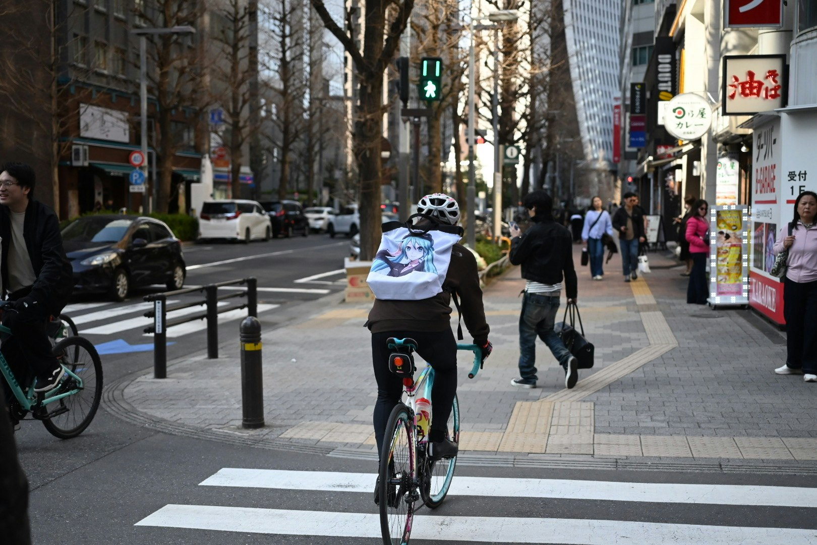 自転車に乗った人物が交差点を渡る様子と都市の風景