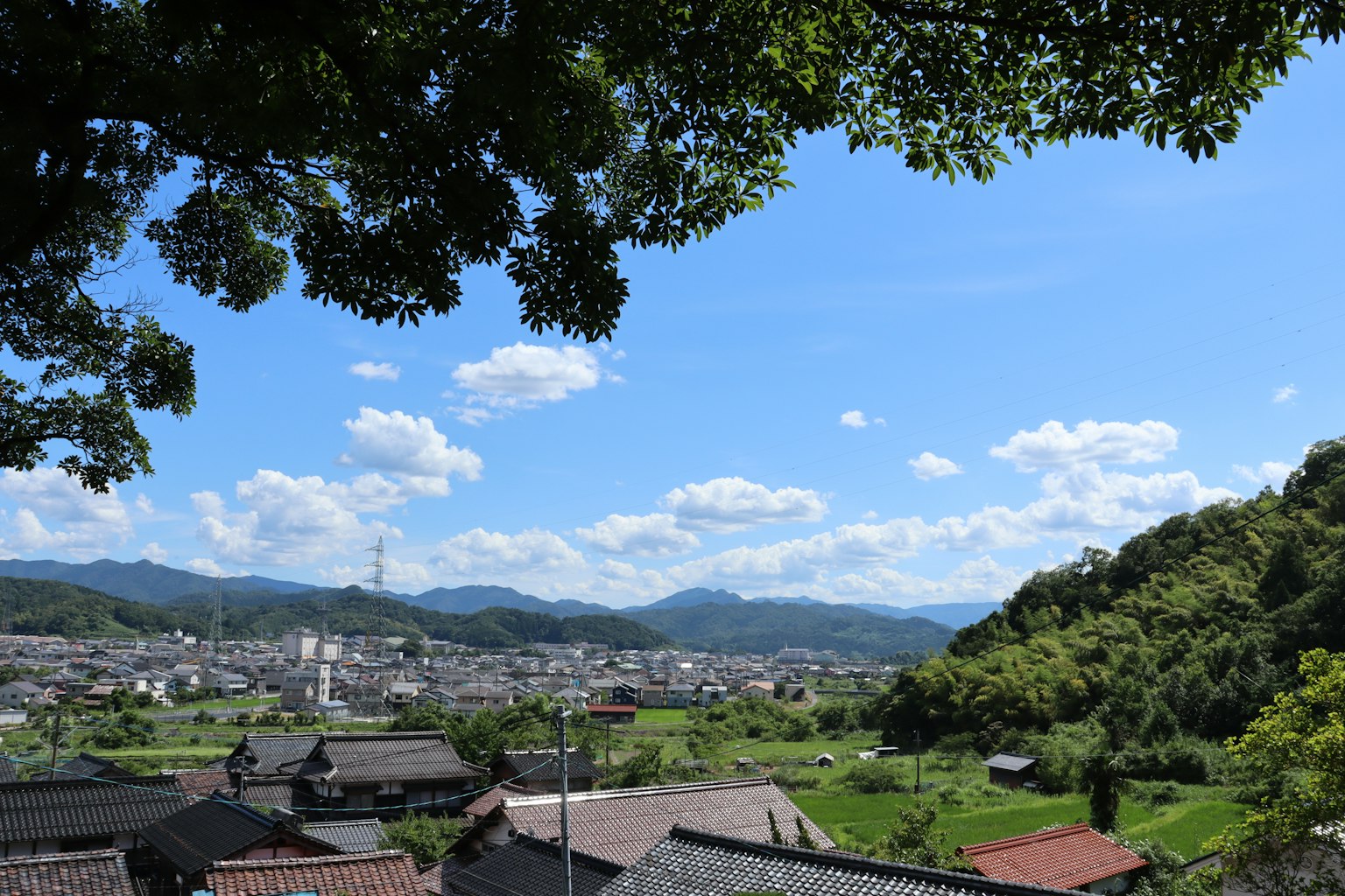 乡村风景 蓝天和群山背景下古老房屋散落在绿色区域
