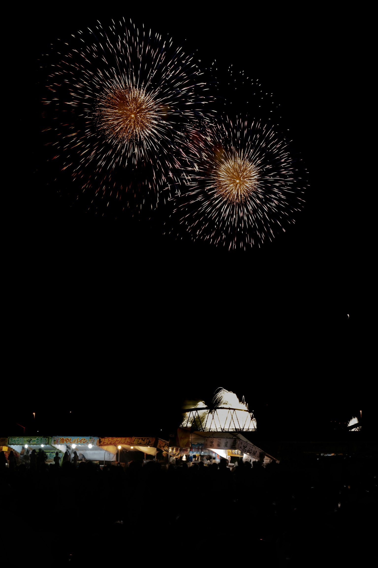 夜空中绽放的烟花和下面的人群轮廓