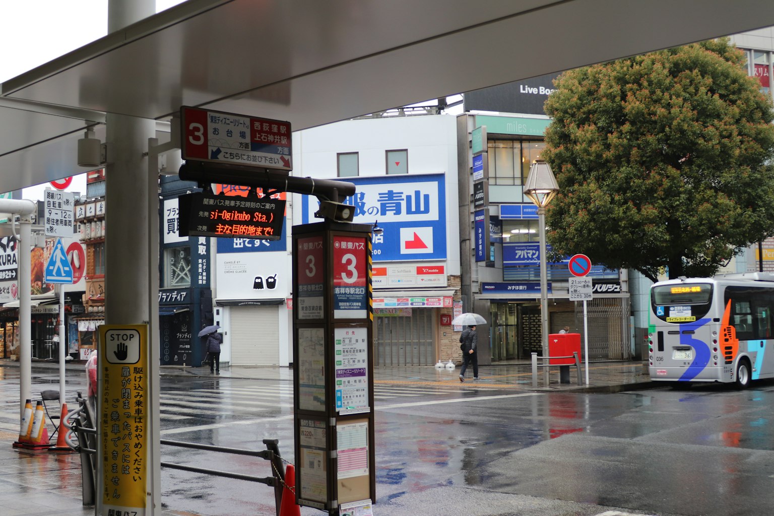 ป้ายรถเมล์ในฝนกับทิวทัศน์เมือง