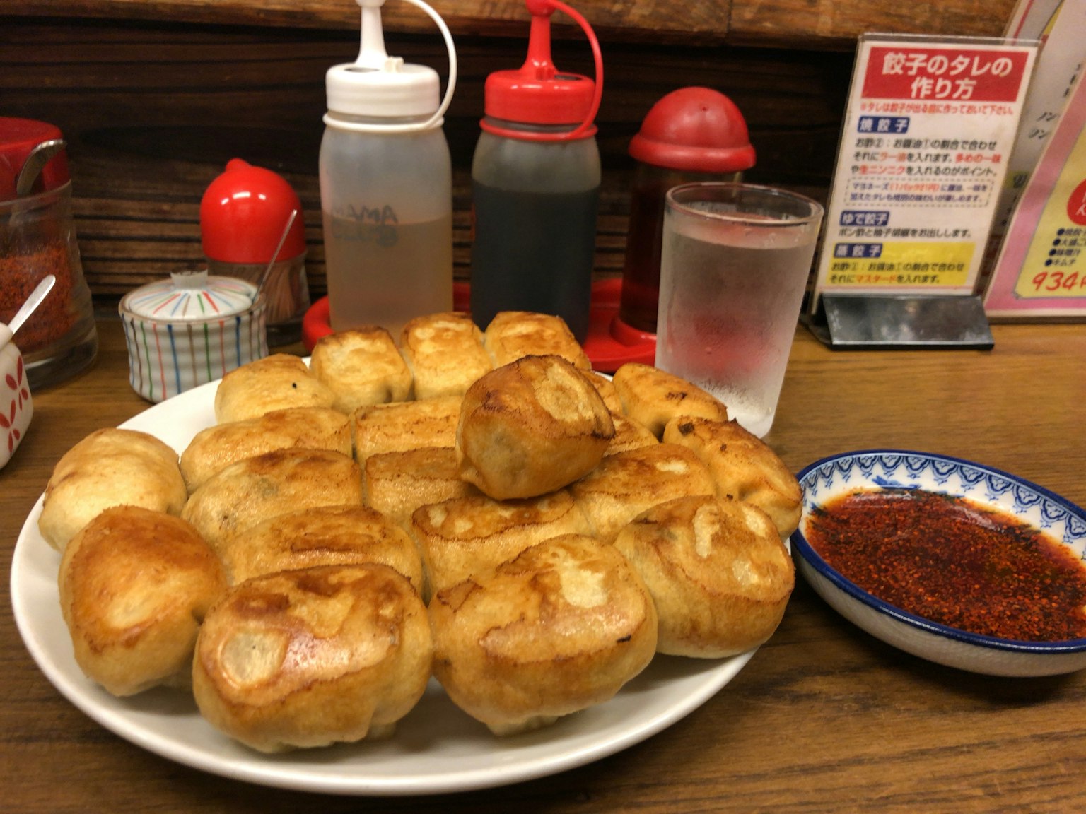 Plateau de raviolis frits dorés avec des bouteilles de condiments