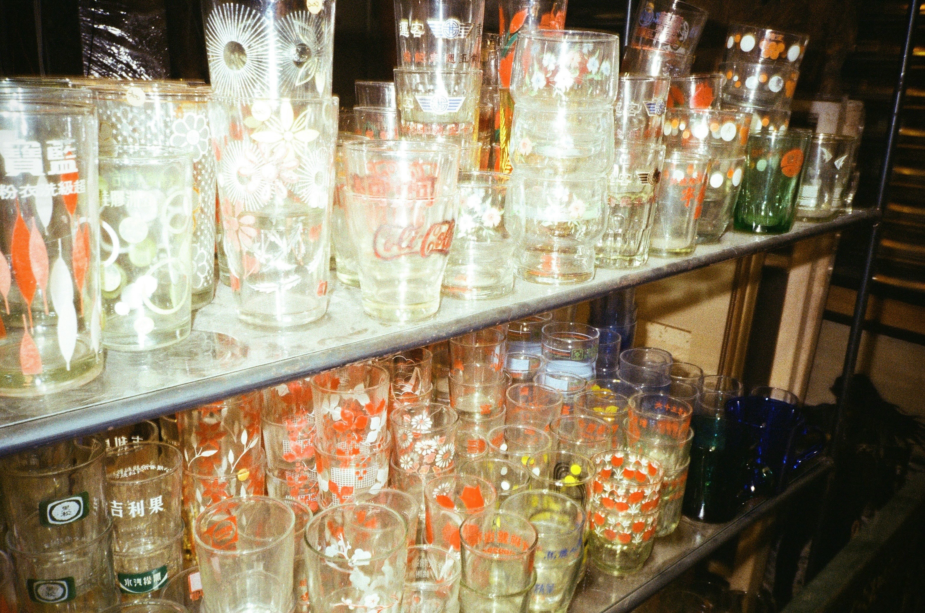 色とりどりのグラスが並ぶ棚の写真