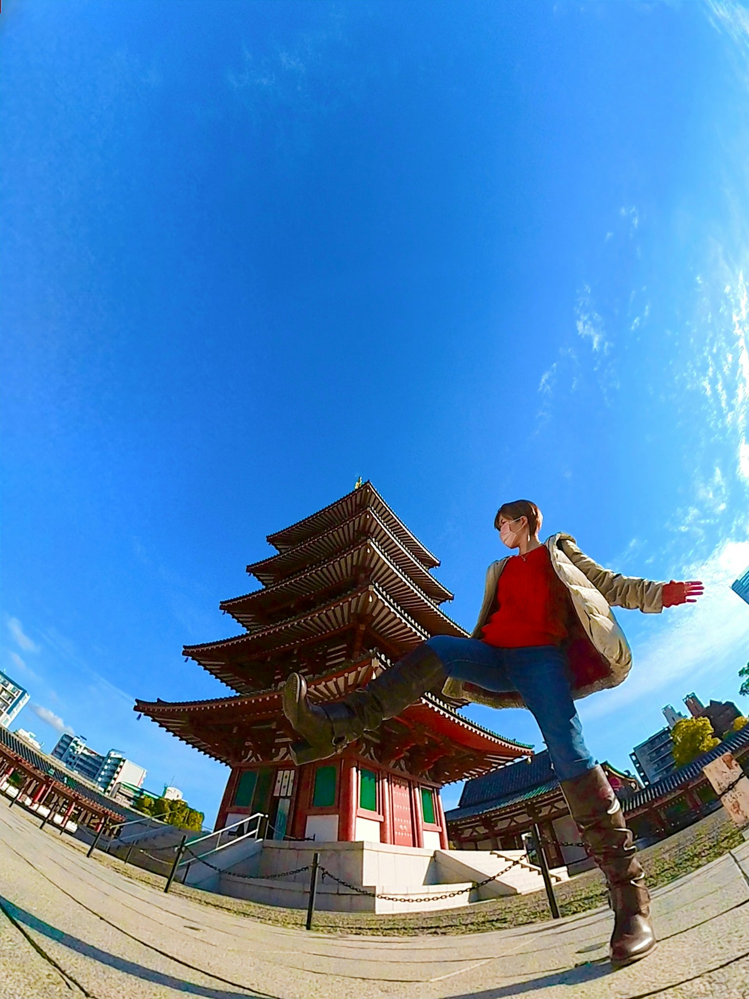 Person unter blauem Himmel mit traditioneller Pagode