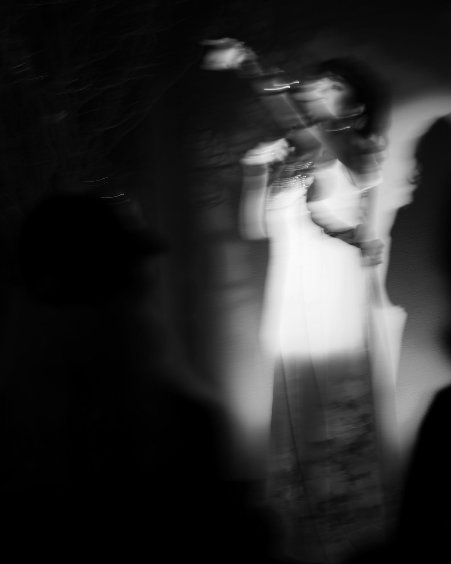 Bóng mờ của một người phụ nữ đang hát trong chiếc váy trắng cầm micro