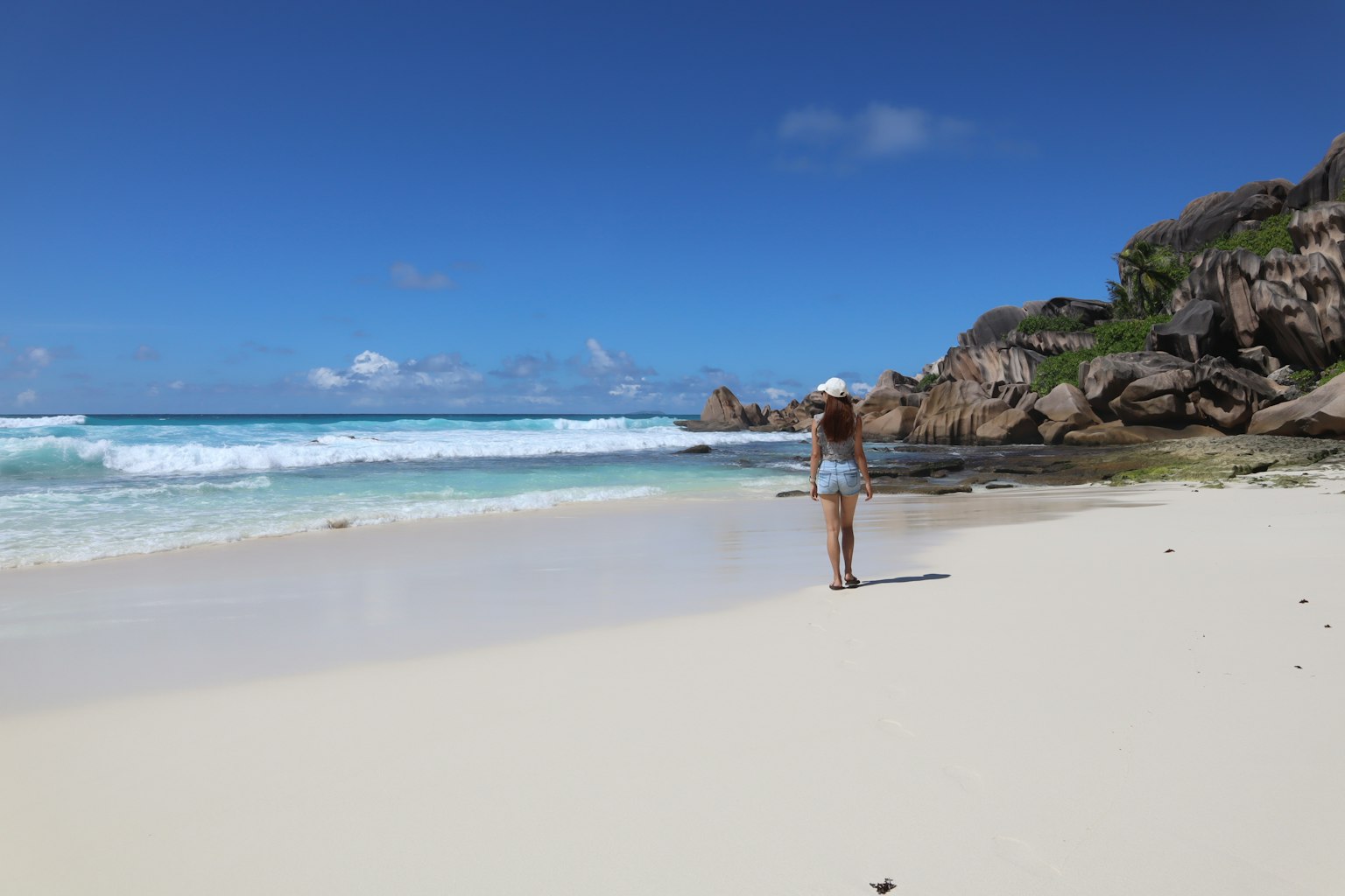 Femme se tenant sur la plage regardant les vagues