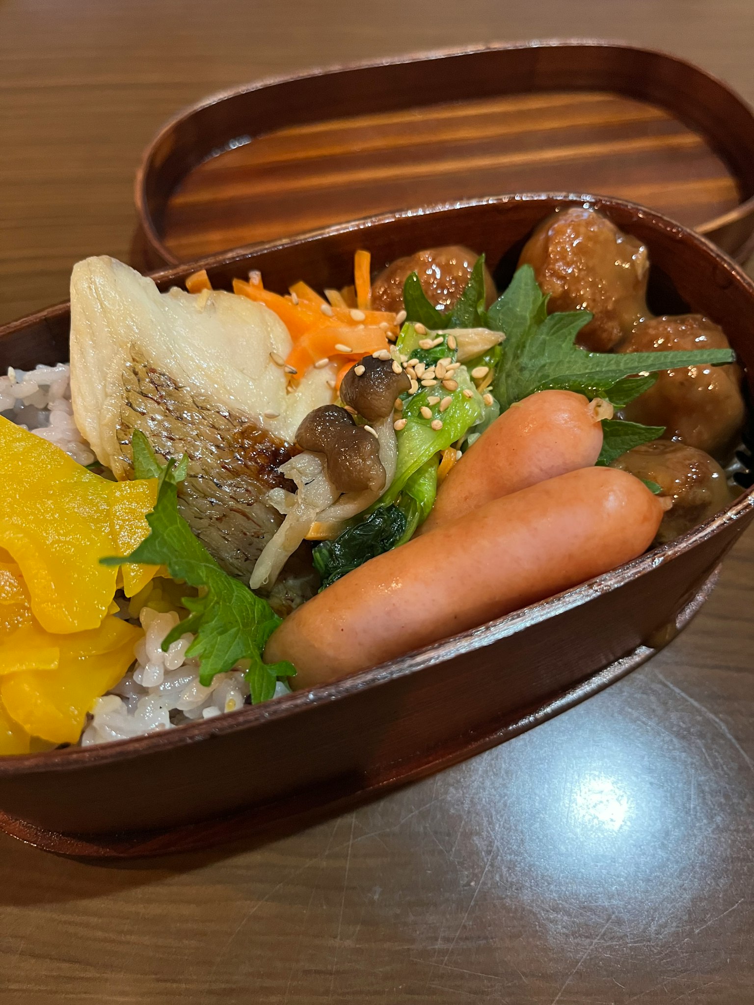Eine Holzbento-Box gefüllt mit Reis und verschiedenen Zutaten