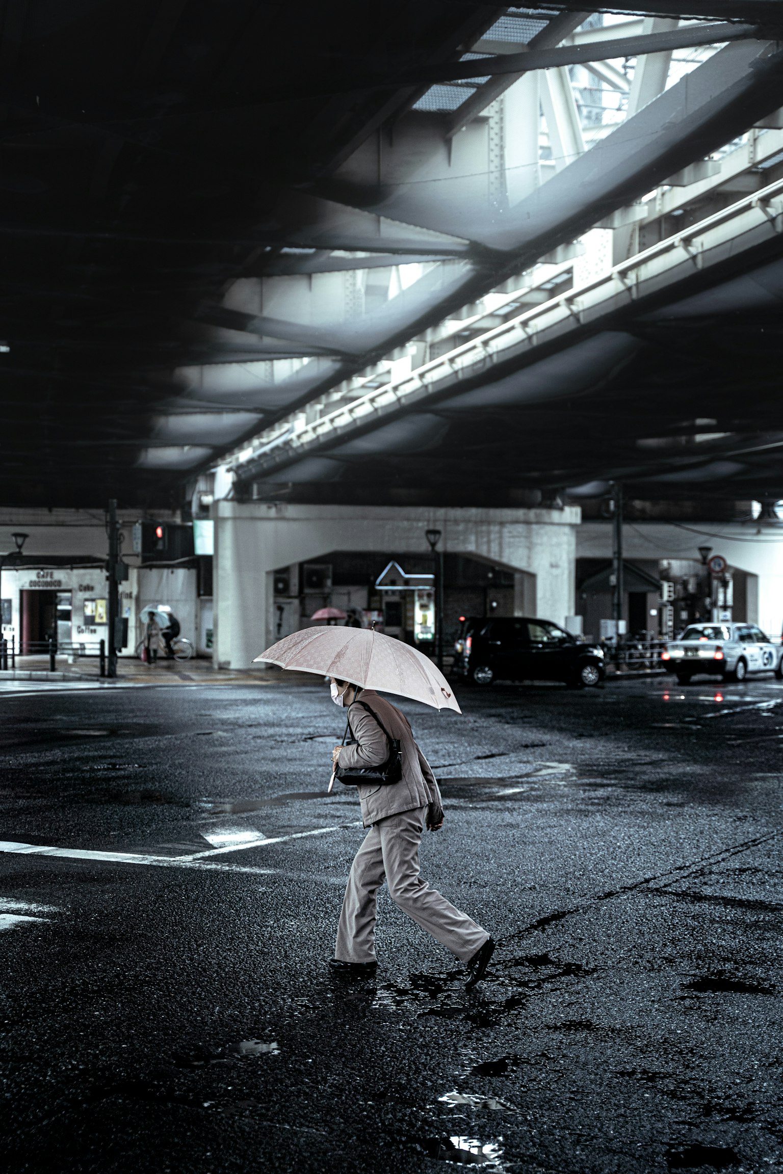 Une personne marchant dans une intersection urbaine avec un parapluie