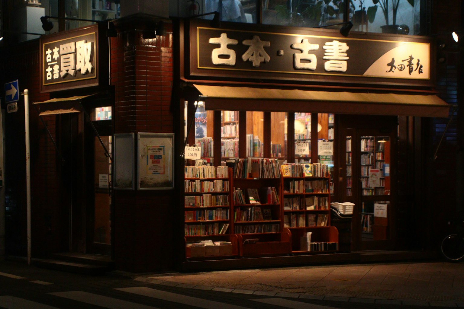 밤에 따뜻한 조명으로 비춰진 중고서점 외관