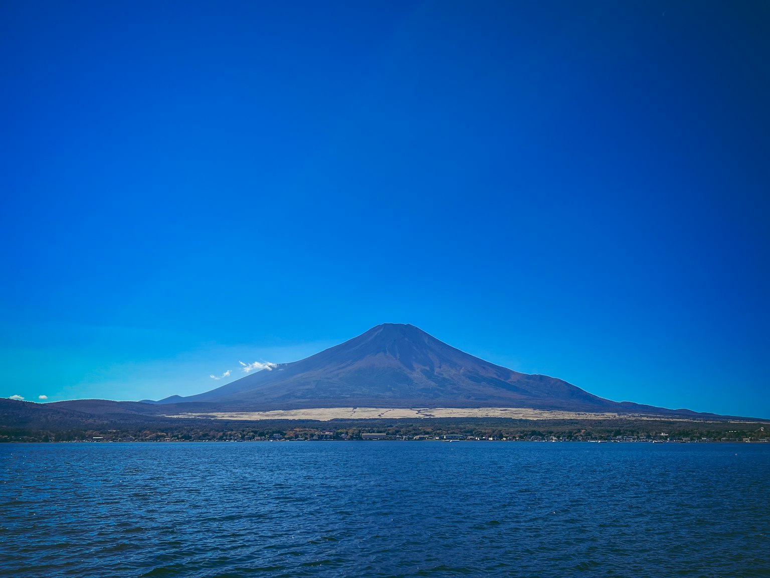 A beautiful mountain landscape towering over a lake under a blue sky