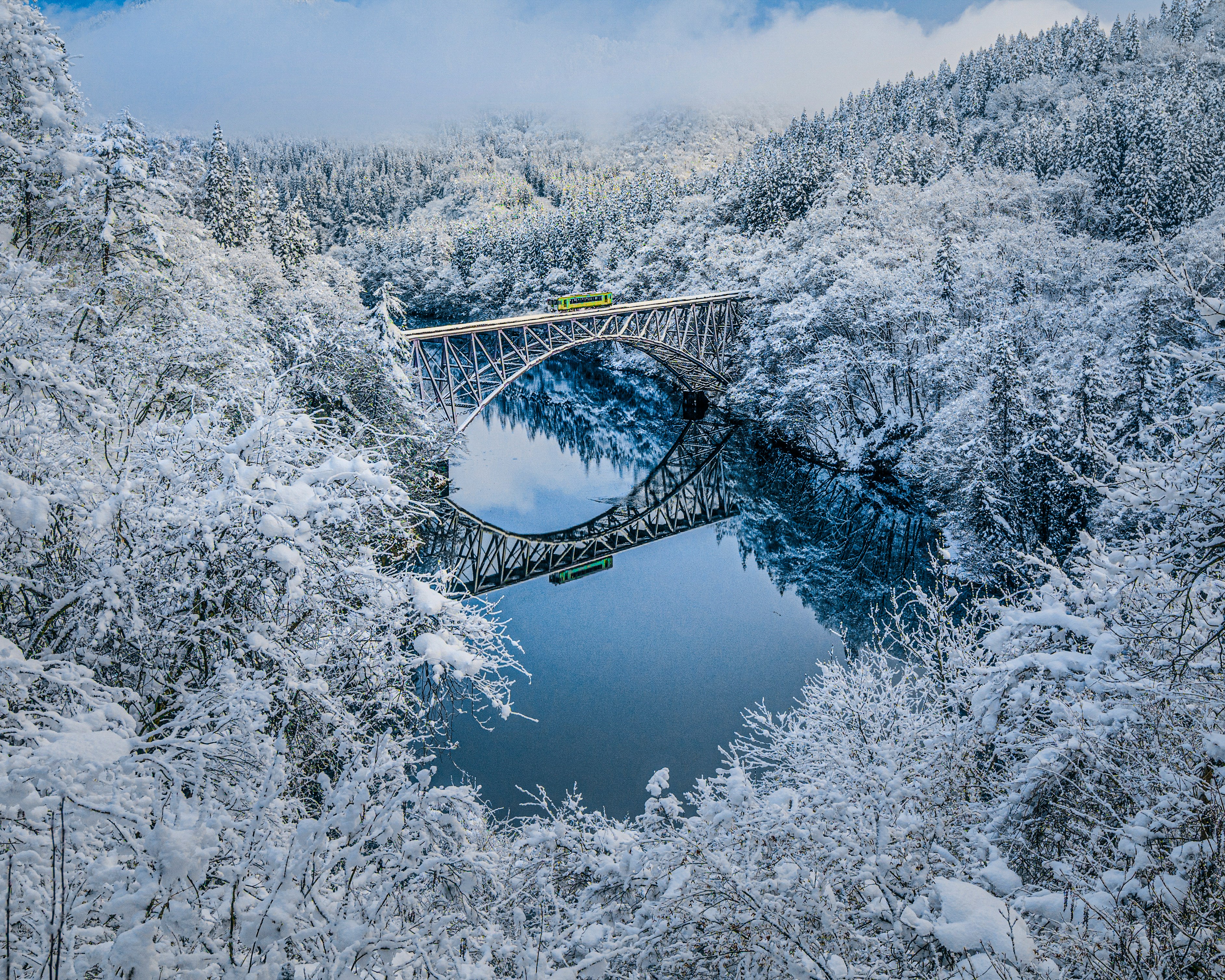 rivière en forêt enneigée et pont en acier