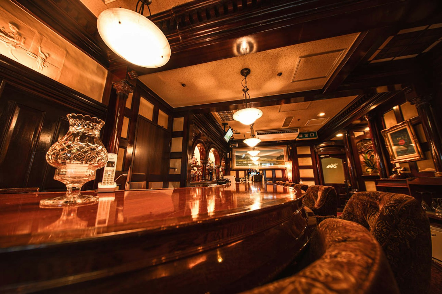 Interior de bar elegante con mesas y sillas de madera iluminación cálida creando una atmósfera acogedora