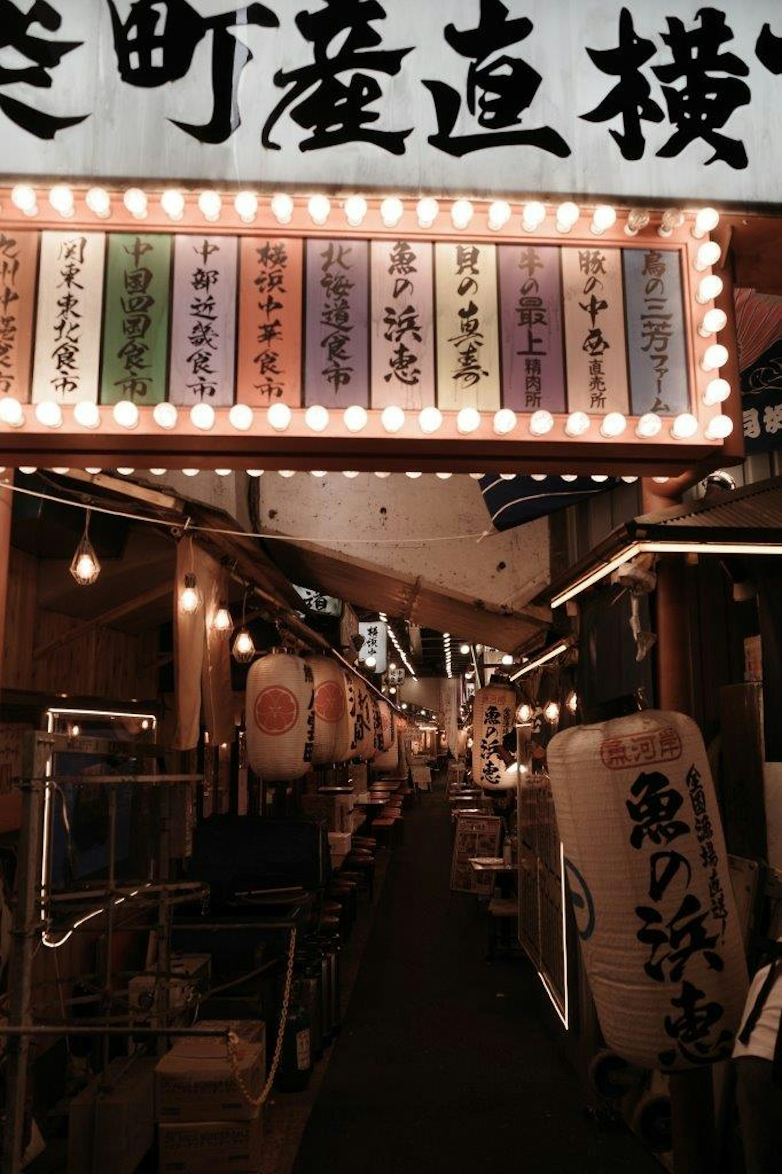 Vibrant street scene of a Japanese food alley with illuminated signs and lanterns