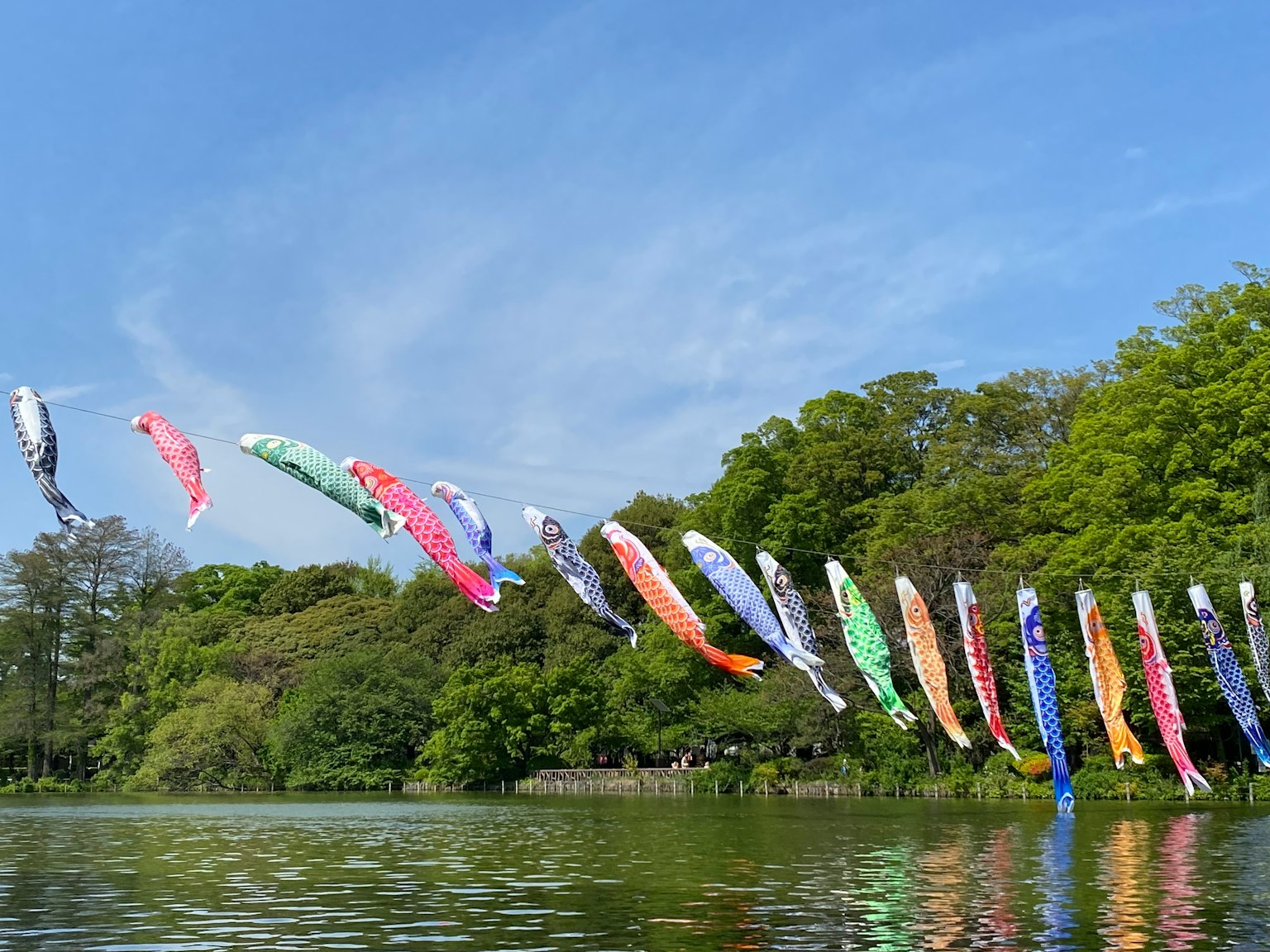 Bunte Koi-Flaggen wehen über dem Wasser unter einem blauen Himmel