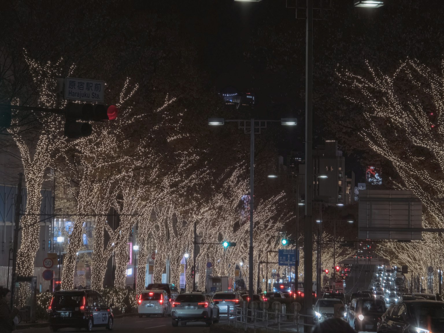 Strada notturna adornata di luci scintillanti e auto in movimento