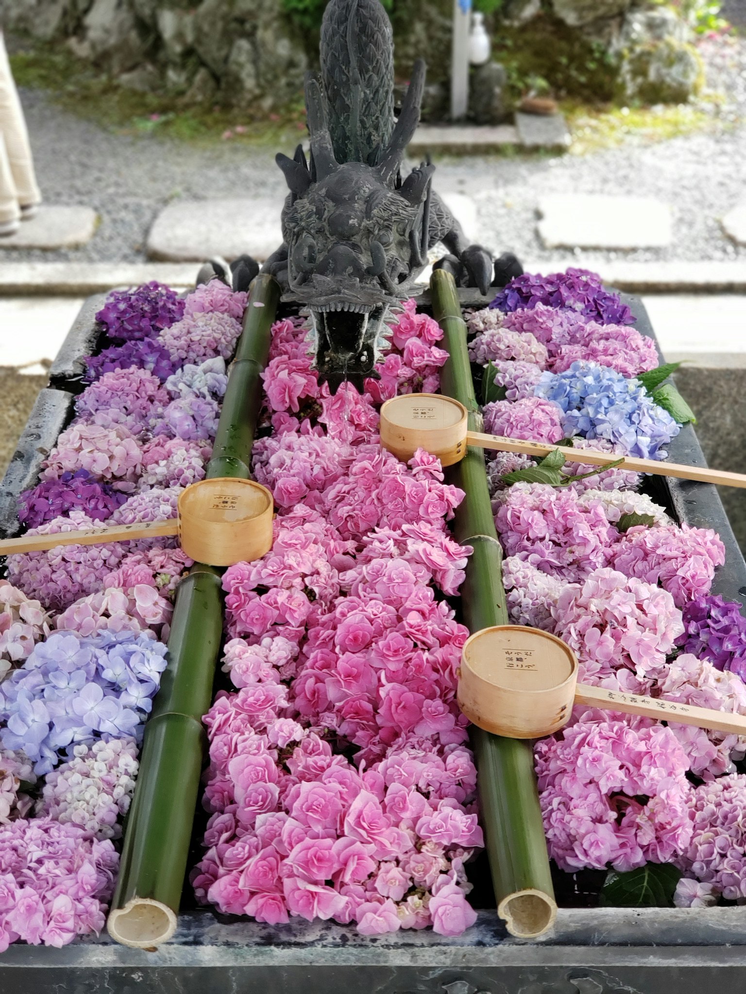 一个用五颜六色的花和竹水舀子装饰的水池