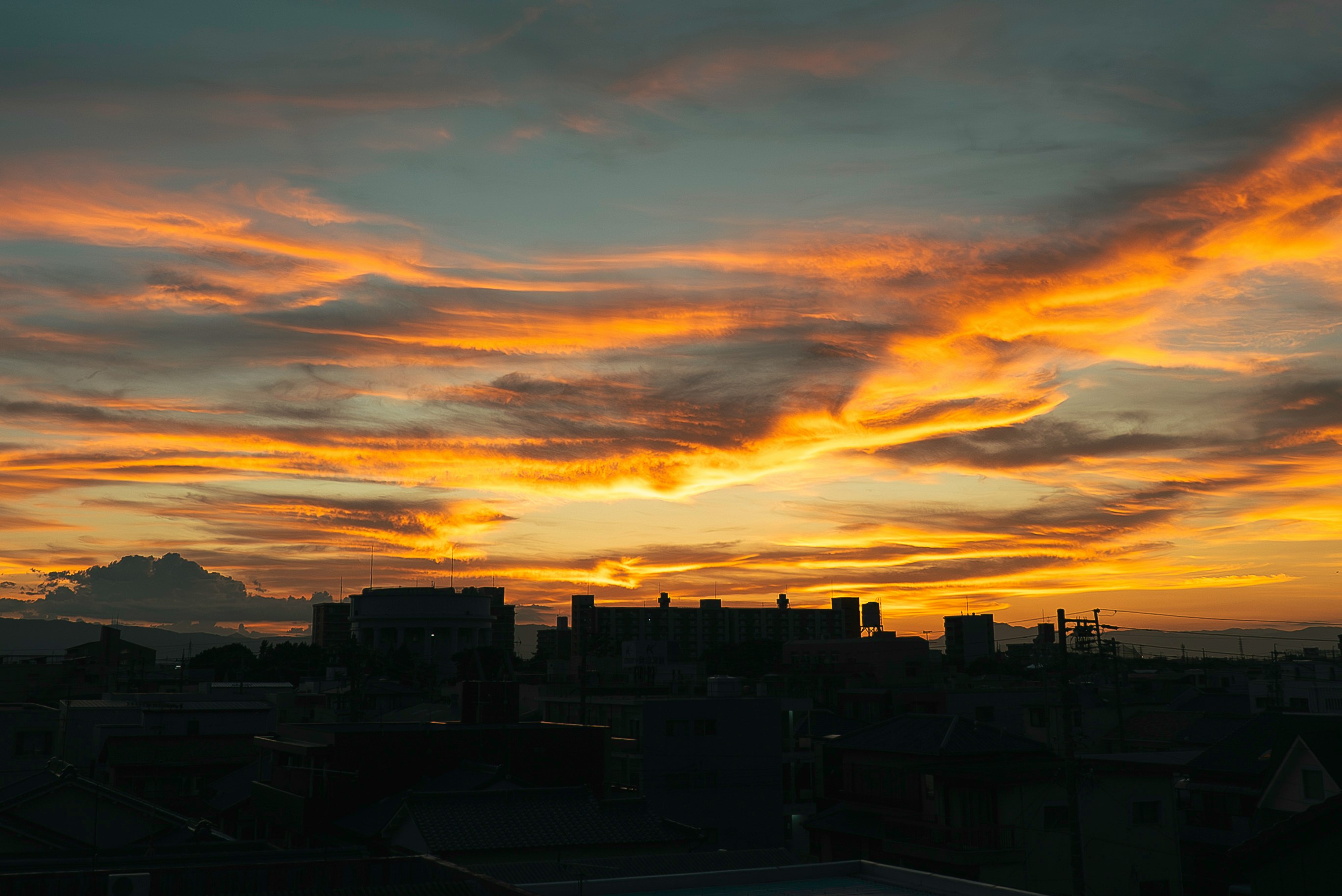 Stadt-Skyline-Silhouette unter einem Dämmerungshimmel mit dramatischen Wolken