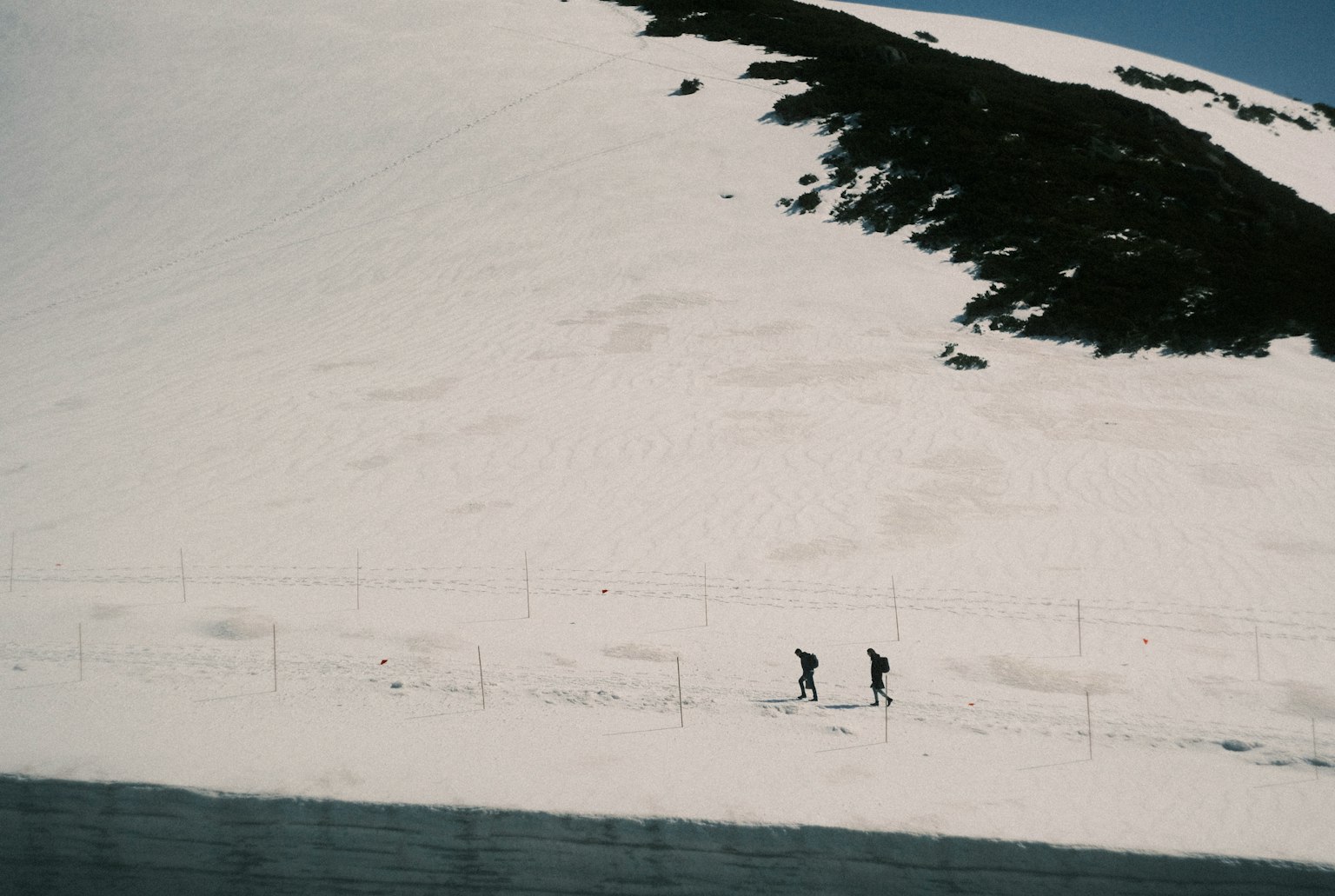 兩名登山者在雪覆蓋的坡道上行走