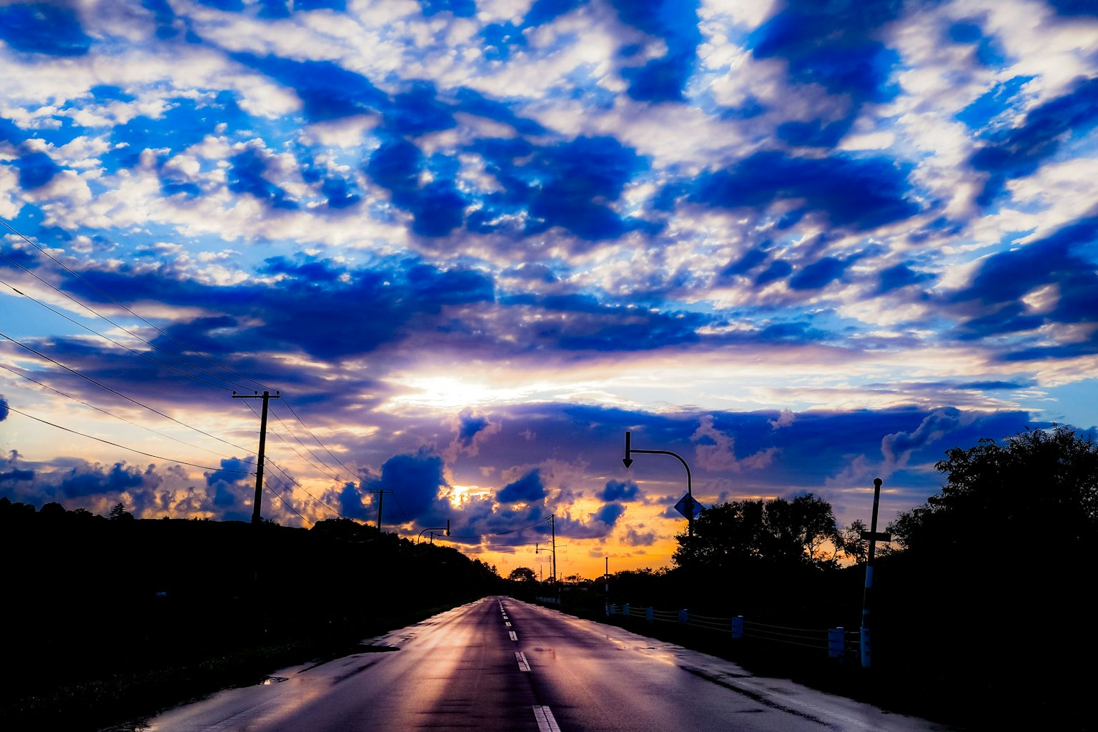 Wunderschöner Sonnenuntergangshimmel mit reflektierender Straße