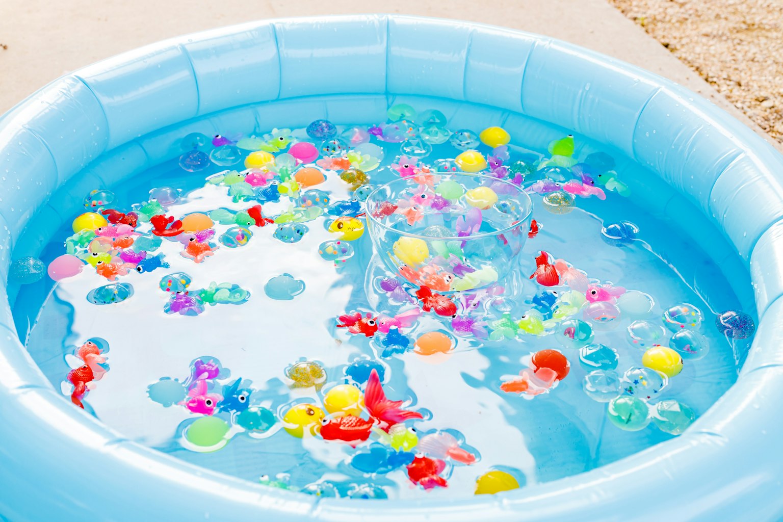 Bola dan mainan berwarna-warni mengapung di kolam renang inflatable biru