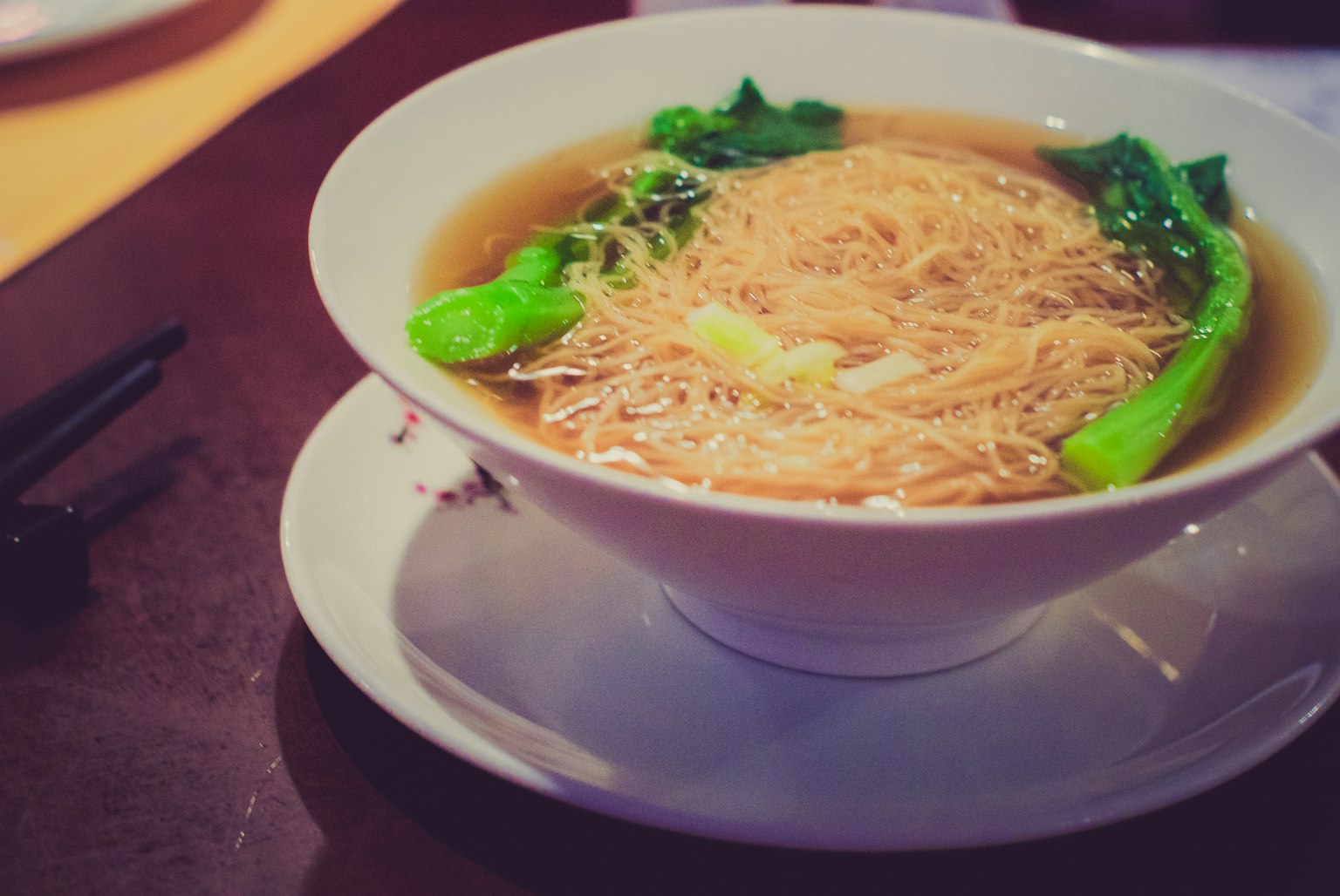 Semangkuk ramen yang dihiasi sayuran dan mie
