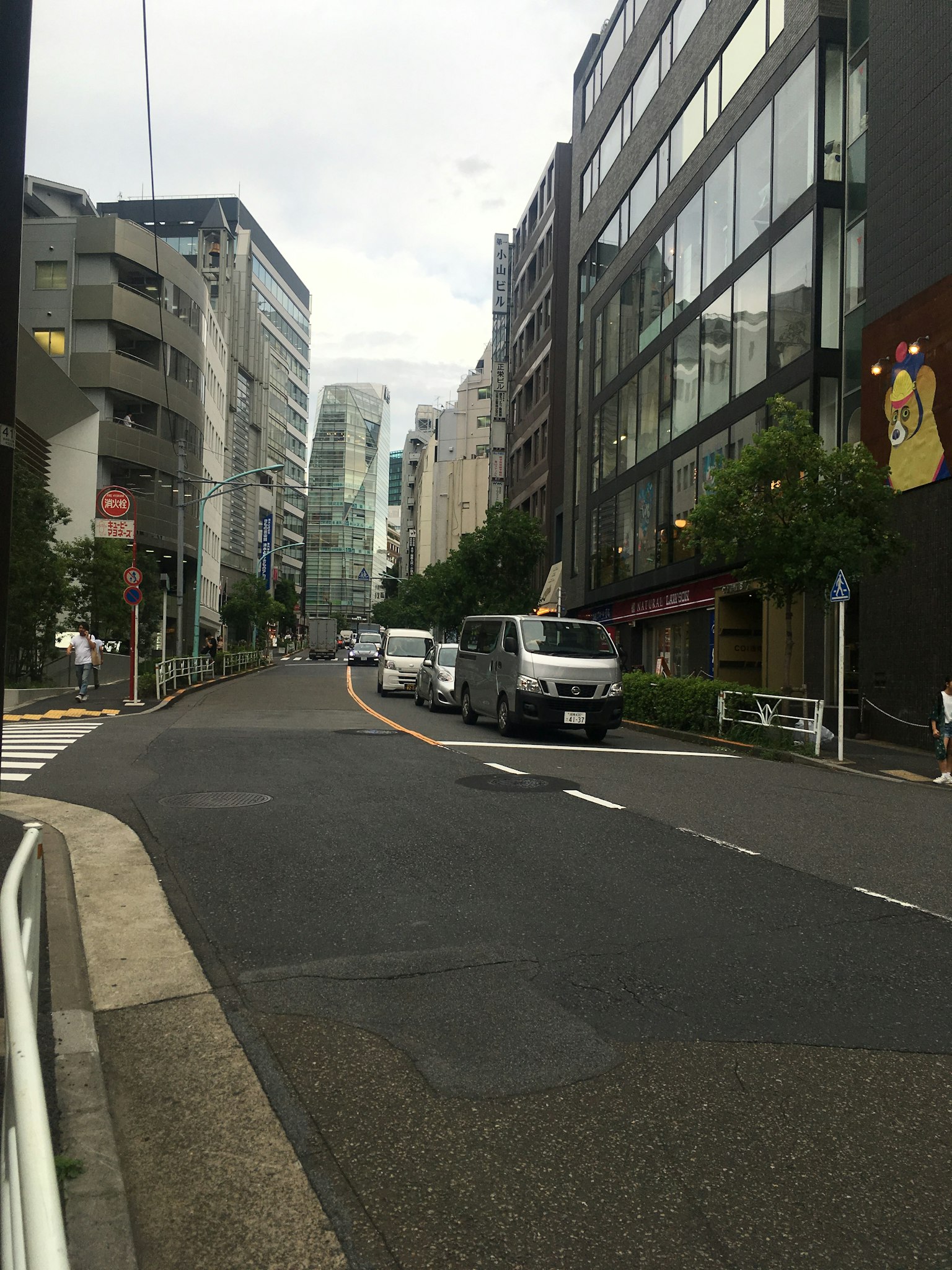 Vista de una calle de la ciudad con edificios y furgones blancos alineados
