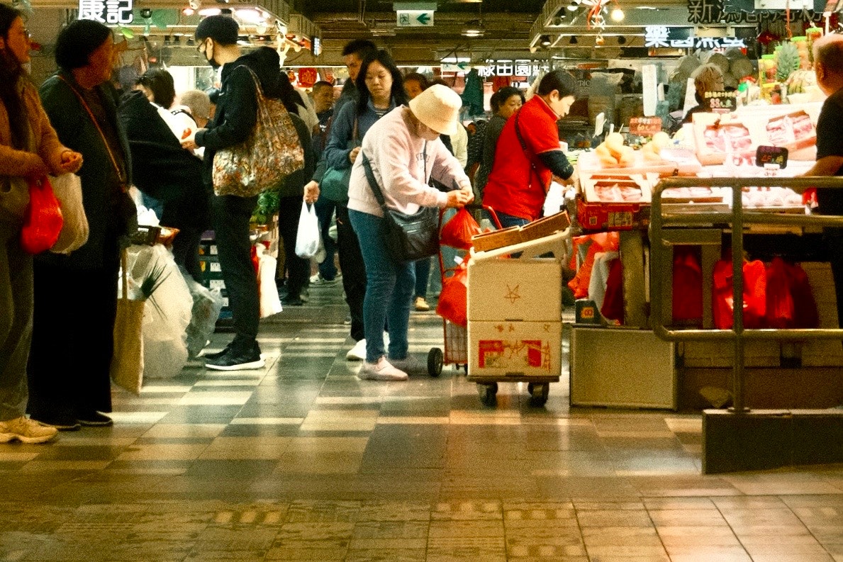 屋内の商店街で買い物客が行き交う屋台の並ぶ通路