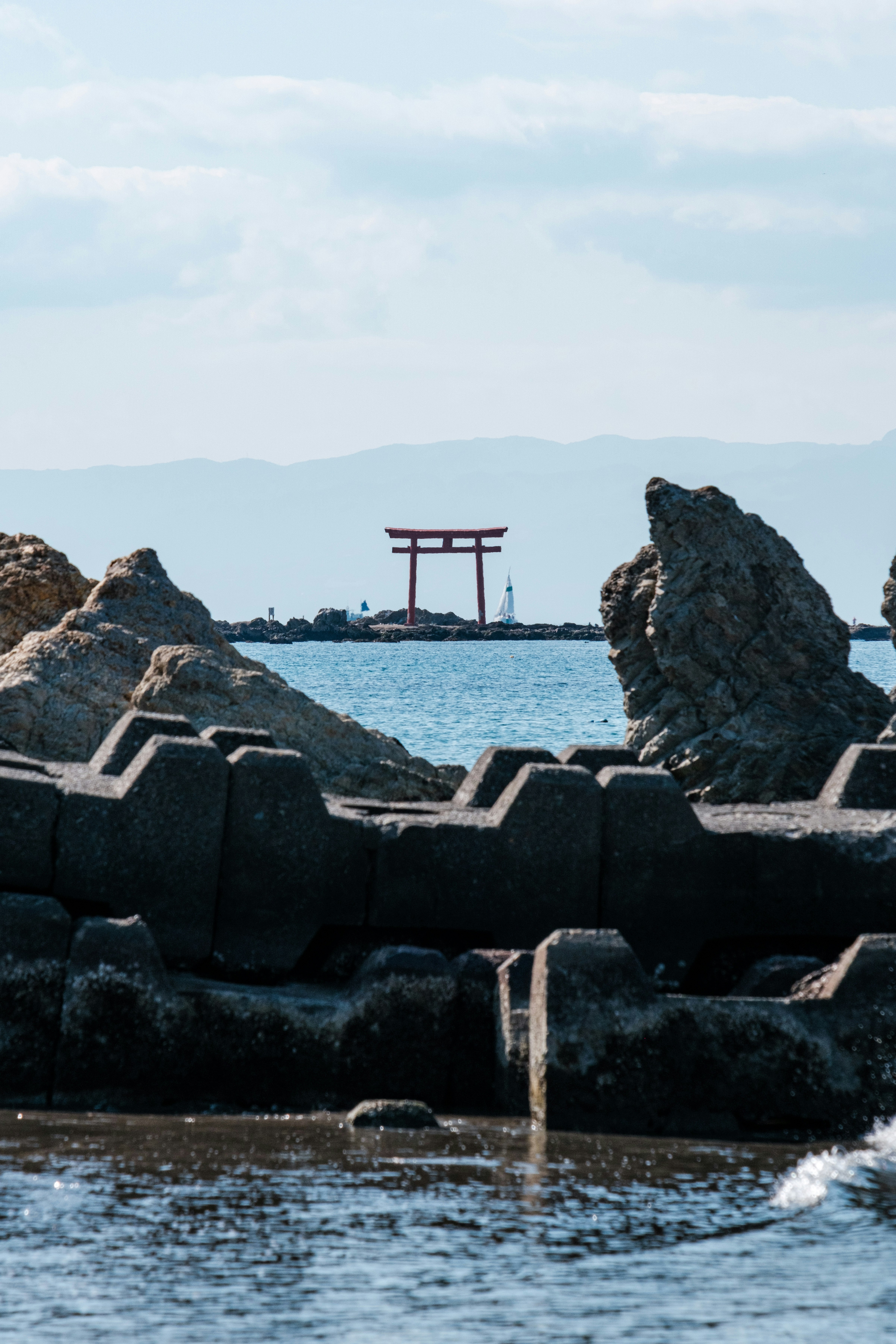 礁石防波堤與海面，遠處的小型桩架