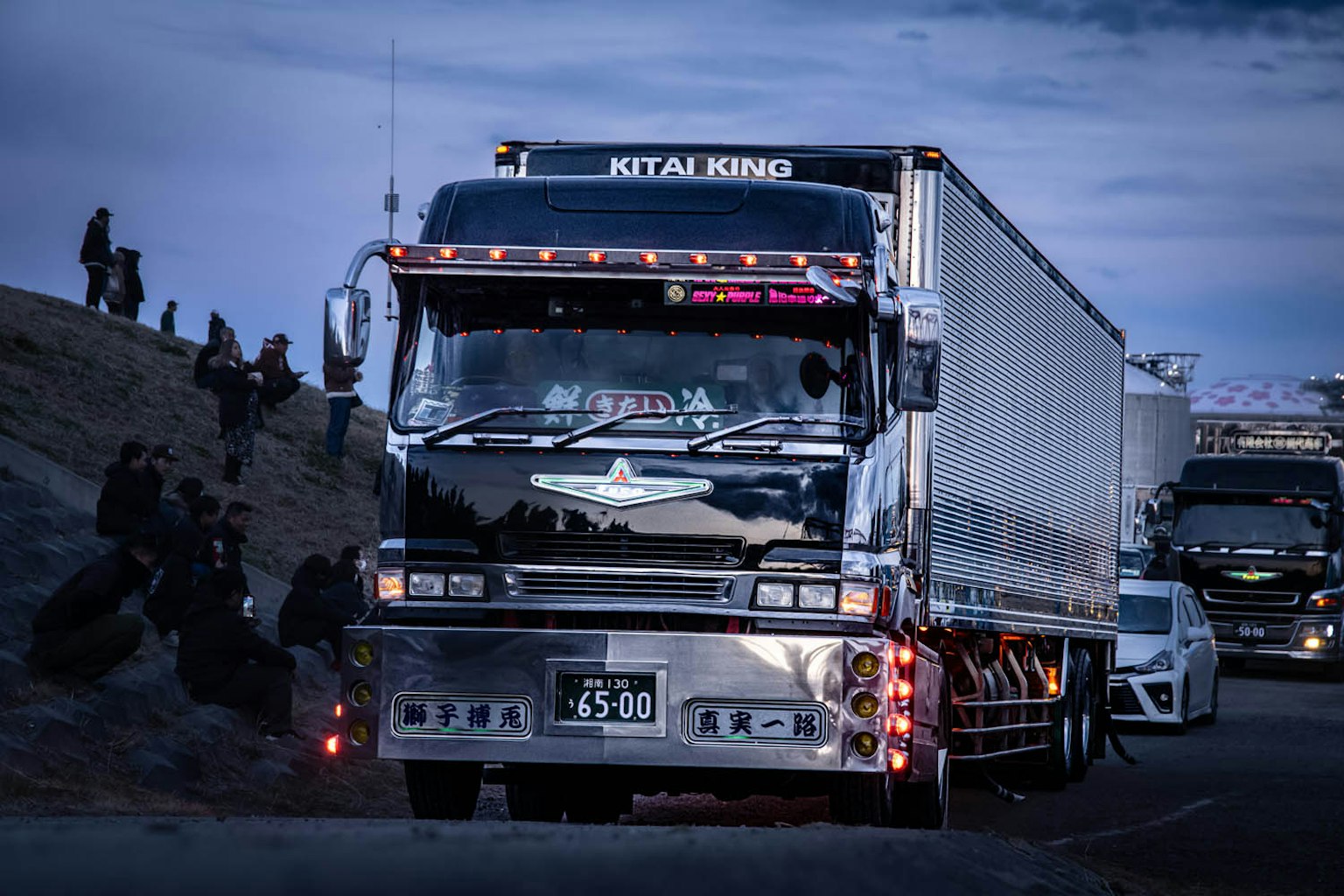 Ein Lkw fährt nachts auf einer Straße mit hellen dekorativen Lichtern