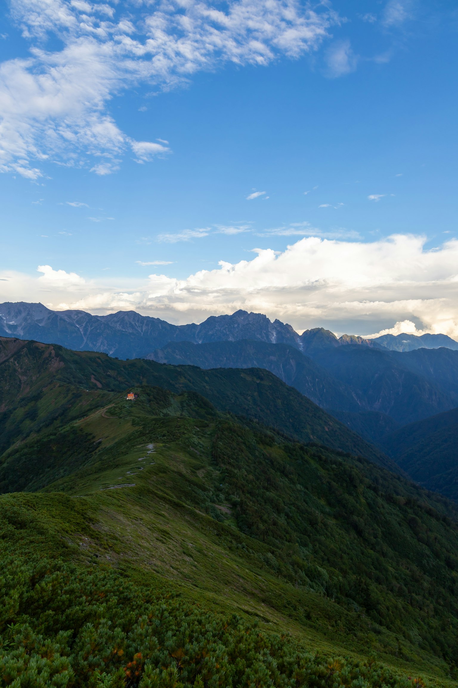 Vista panoramica di montagne verdi sotto un cielo blu