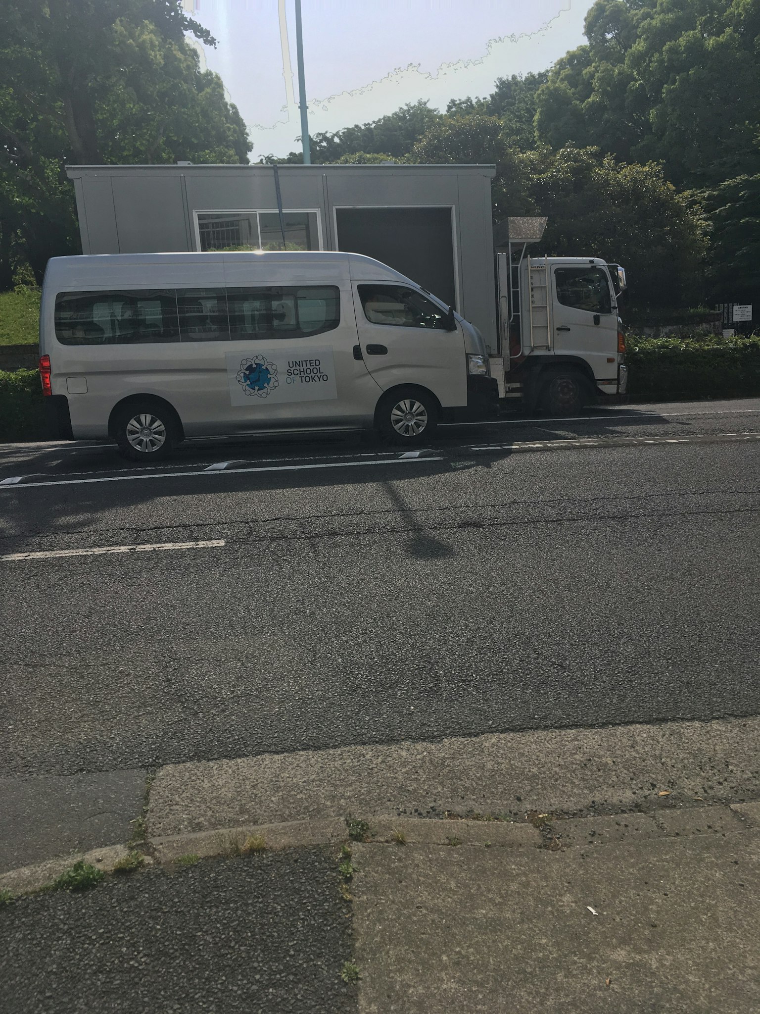 A white van and a truck parked side by side on a city street