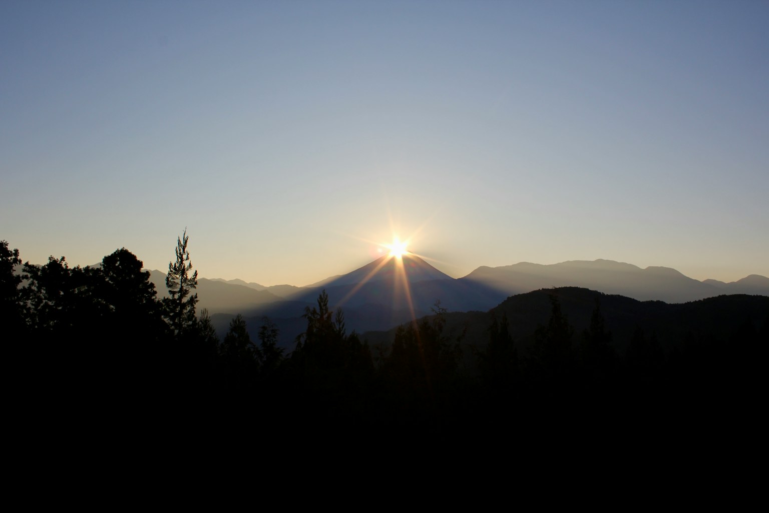 Hermoso paisaje del sol saliendo entre las montañas