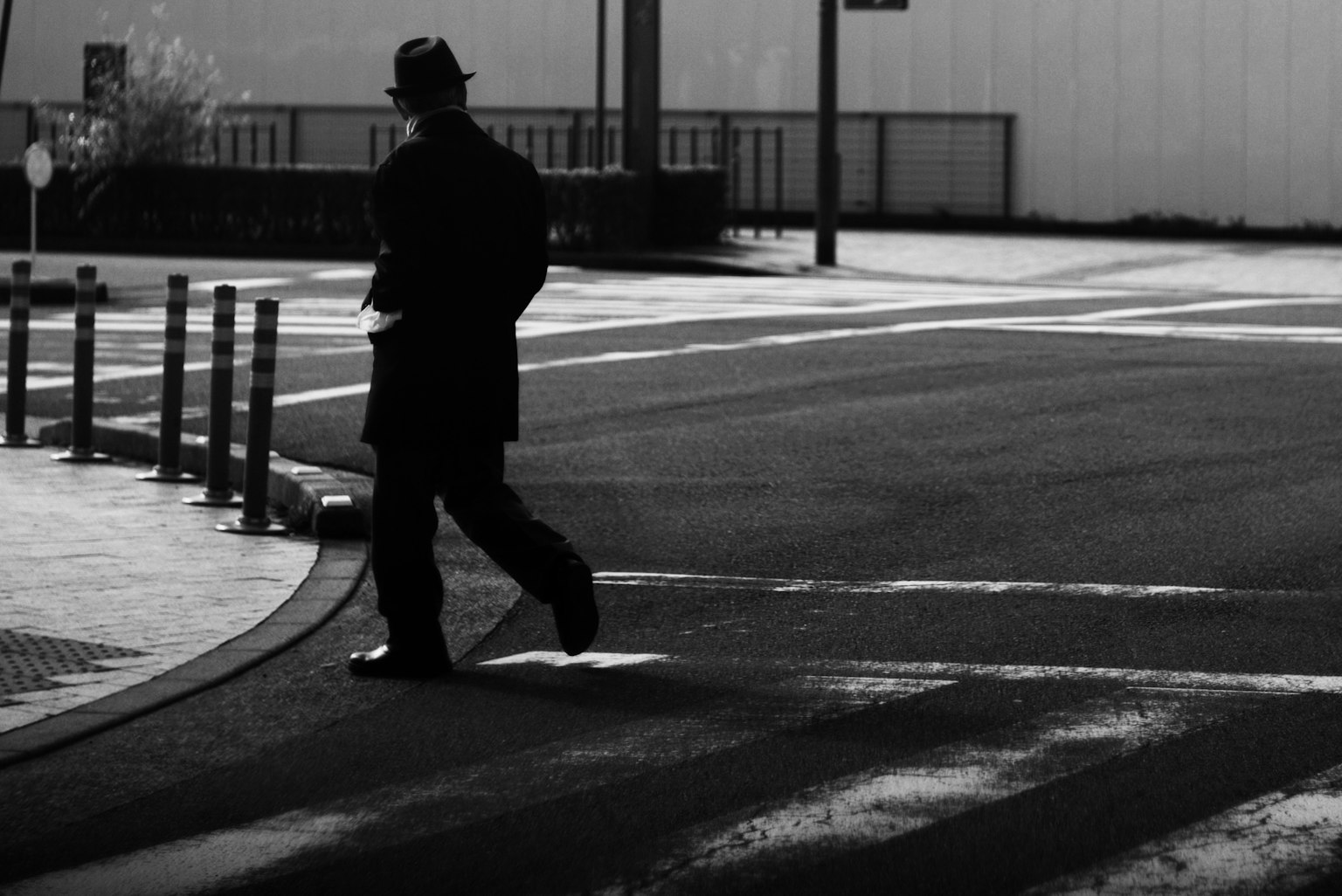 Silhouette d'un homme marchant sur une rue en noir et blanc
