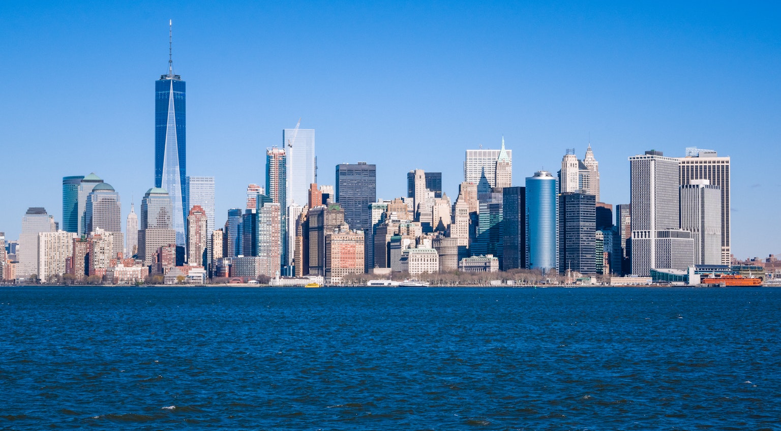 Skyline von New York mit Wolkenkratzern und klarem blauen Himmel über dem Wasser