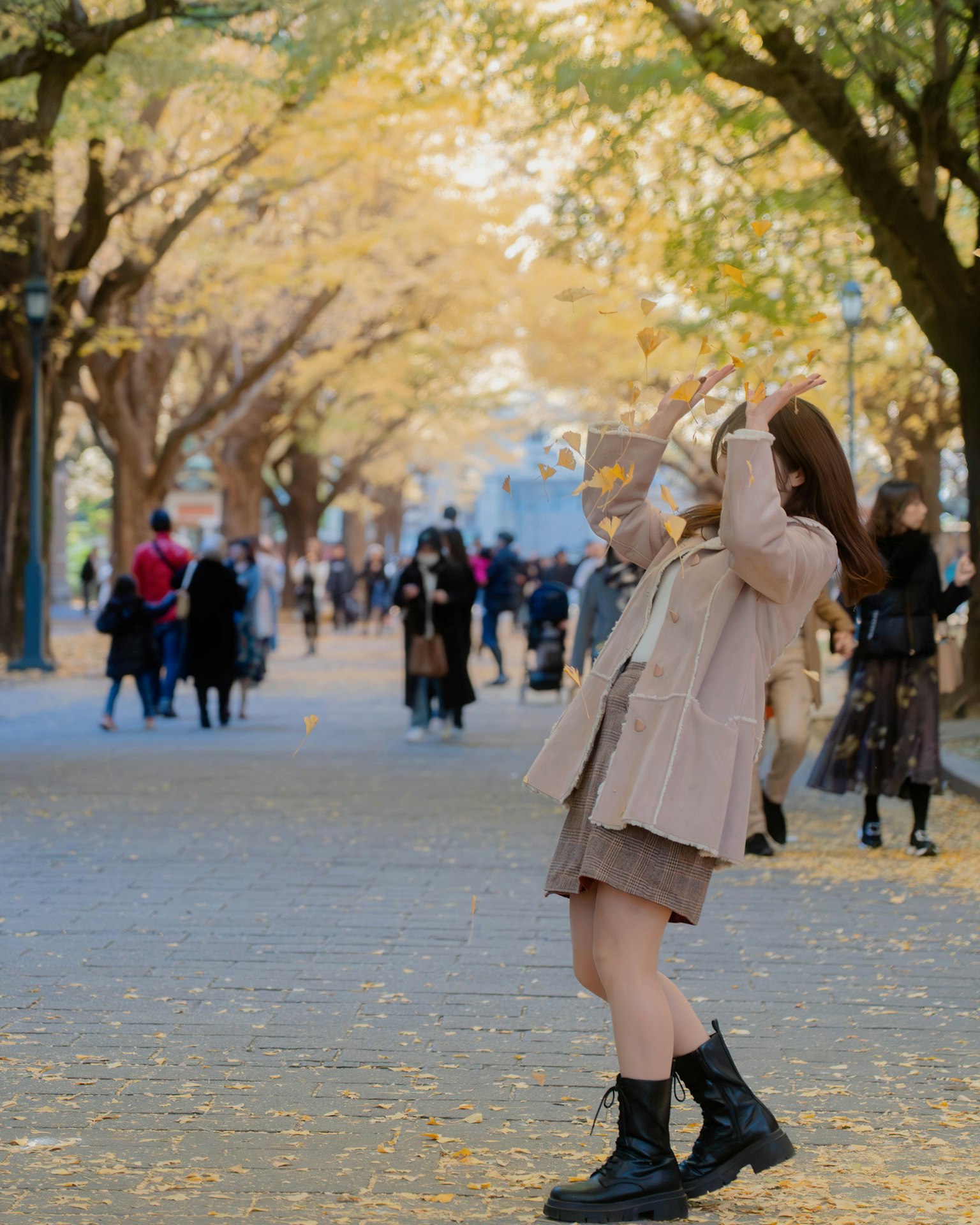 Woman enjoying autumn scenery with yellow leaves
