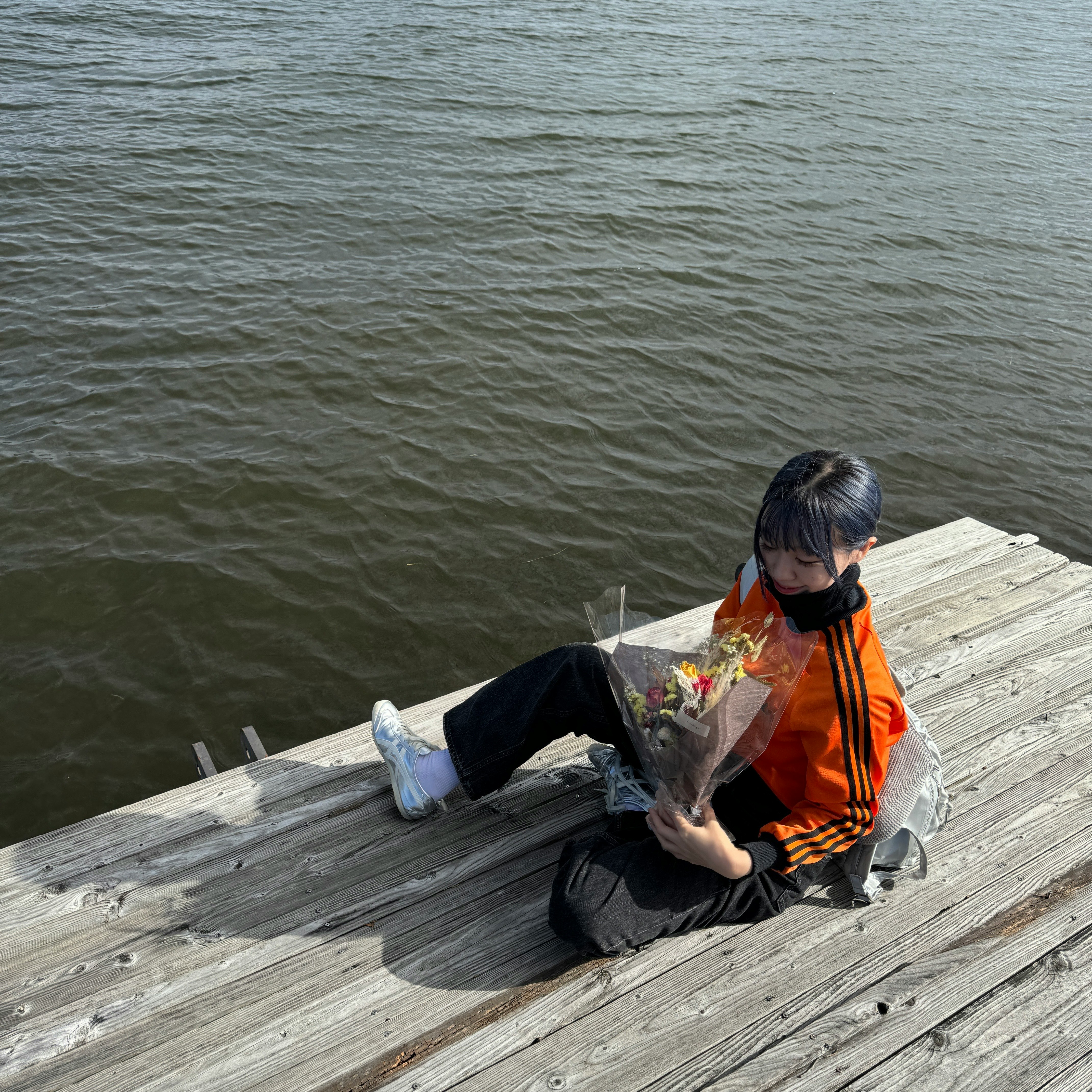 enfant tenant un bouquet sur le bord d’un quai