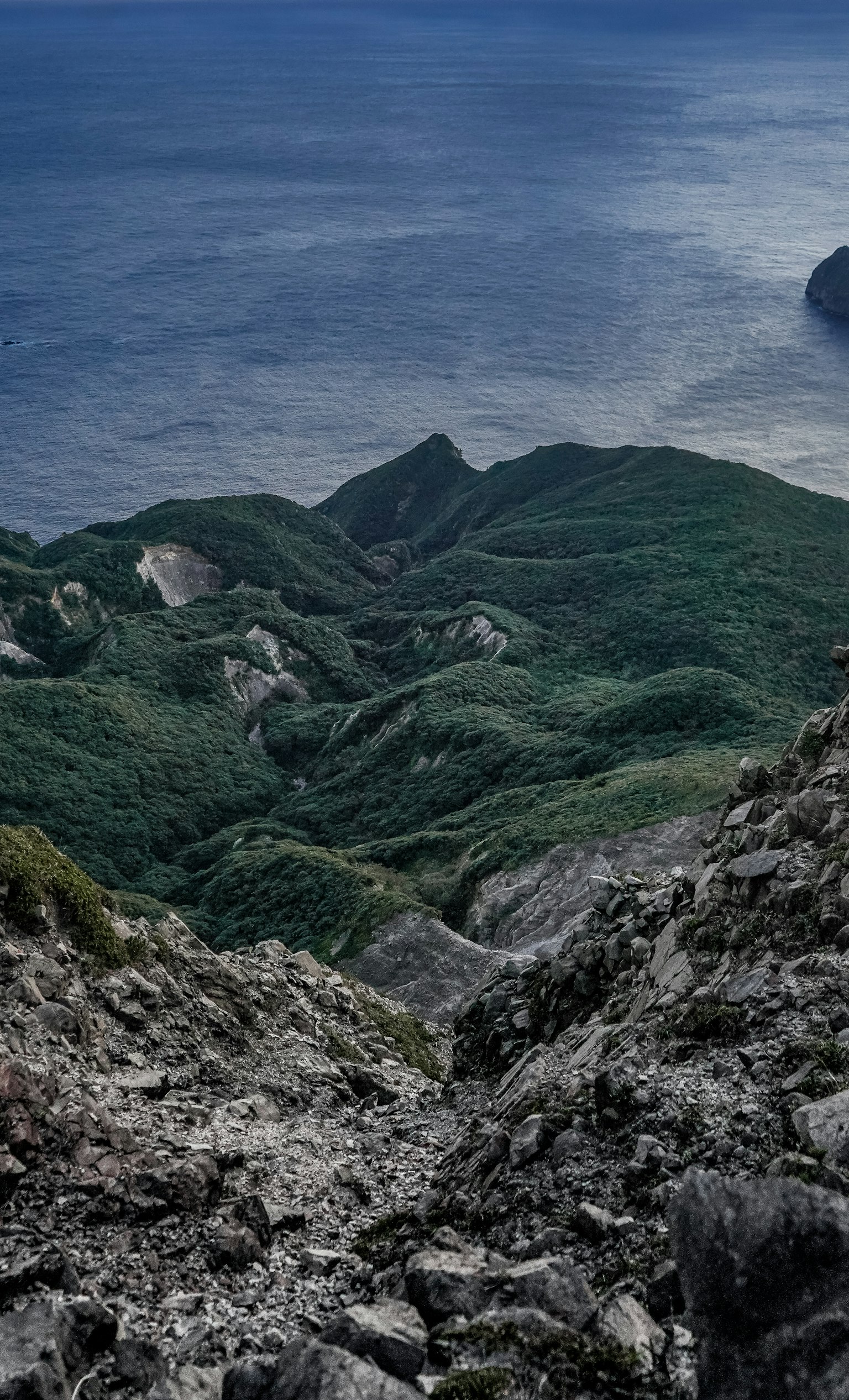 Địa hình đá nhìn ra đại dương xanh và núi xanh