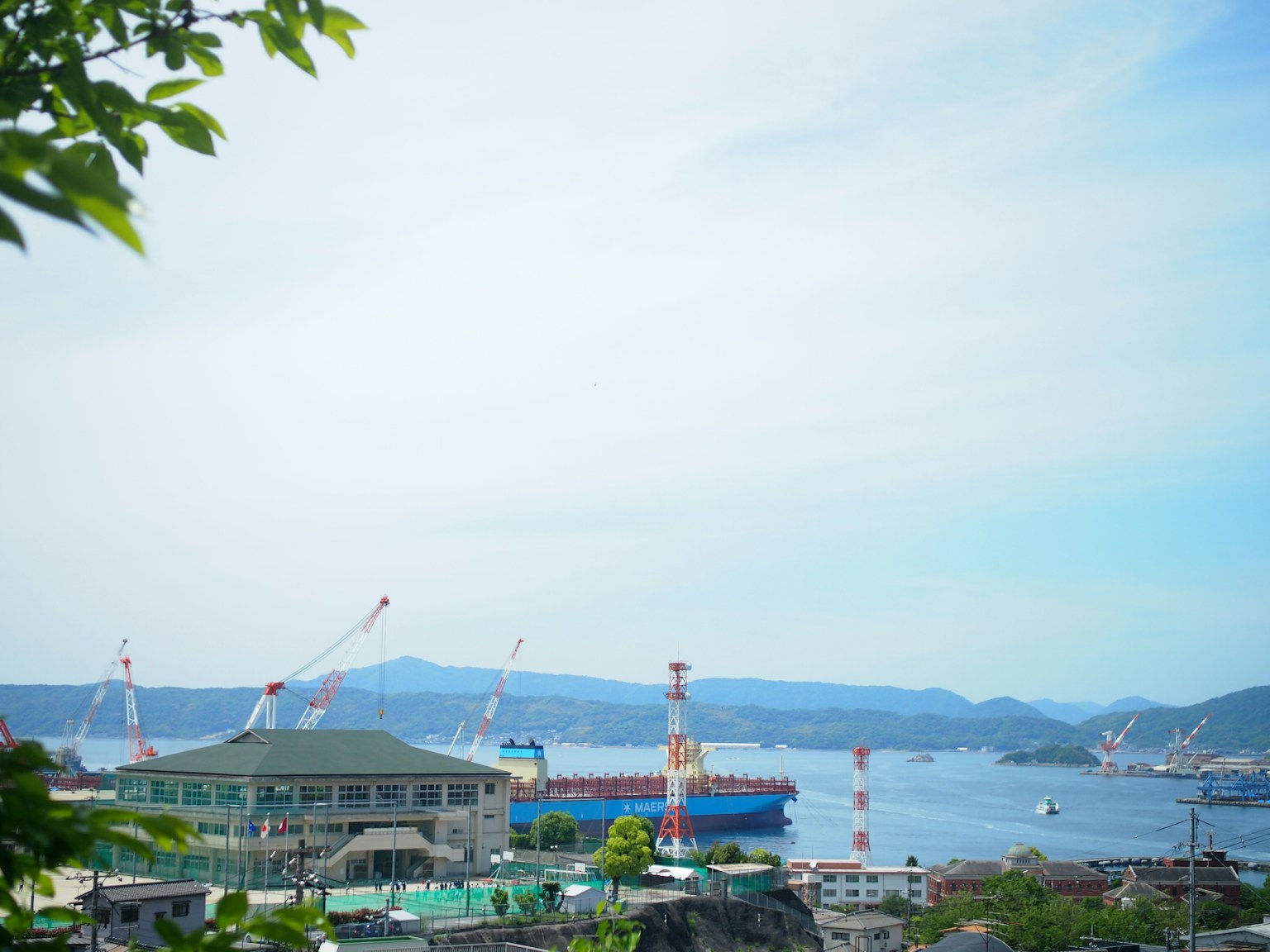 ทิวทัศน์ท่าเรือกับท้องฟ้าสีฟ้าและเครนบนเรือ