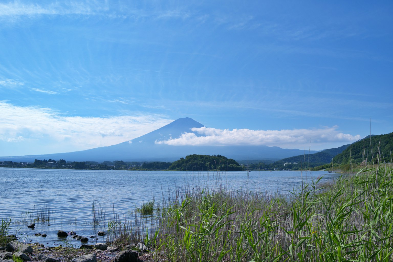Malersiche Aussicht auf den Fuji unter einem blauen Himmel neben einem ruhigen See
