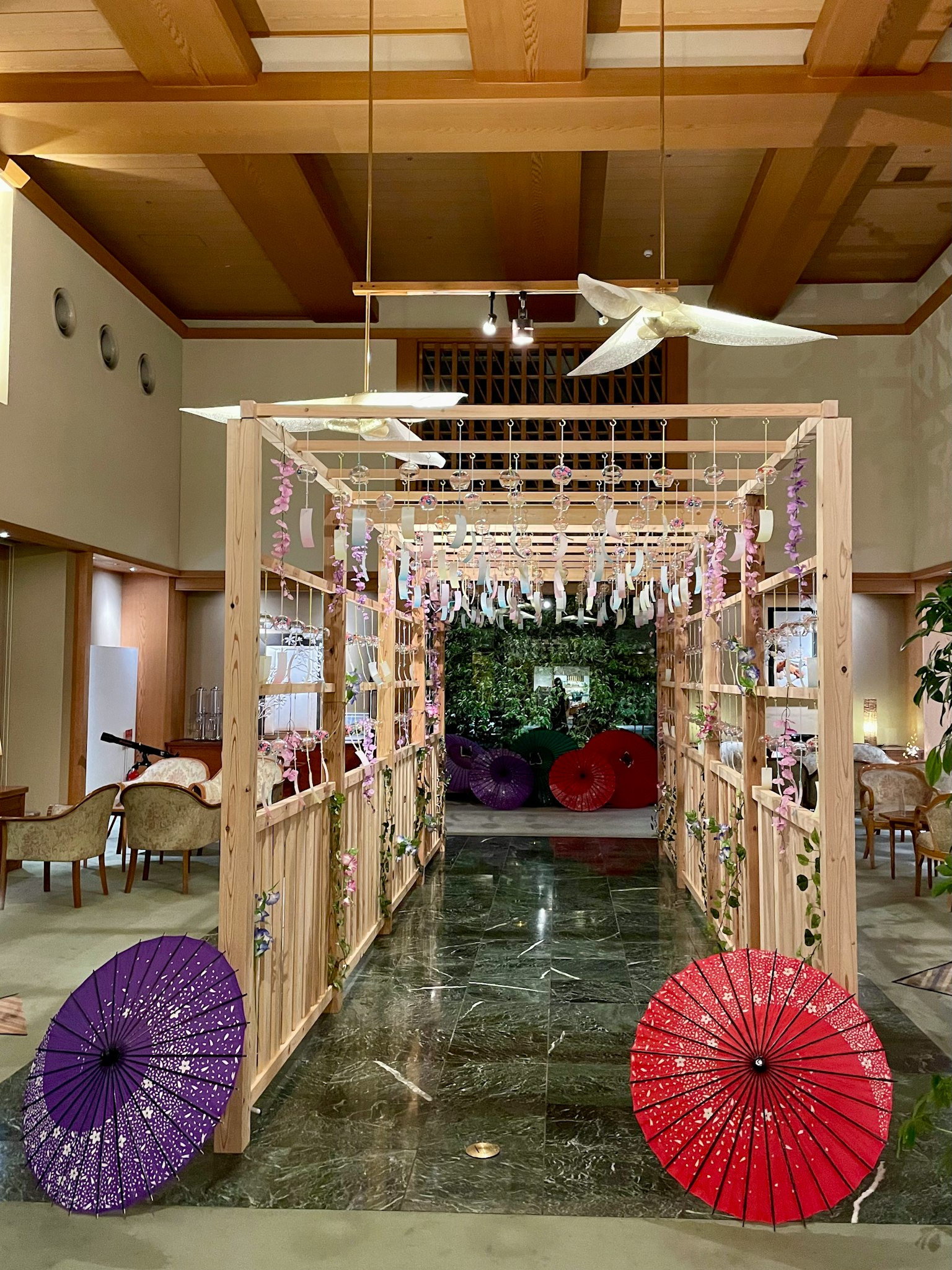 Entrance featuring a wooden arch with colorful umbrellas on the floor